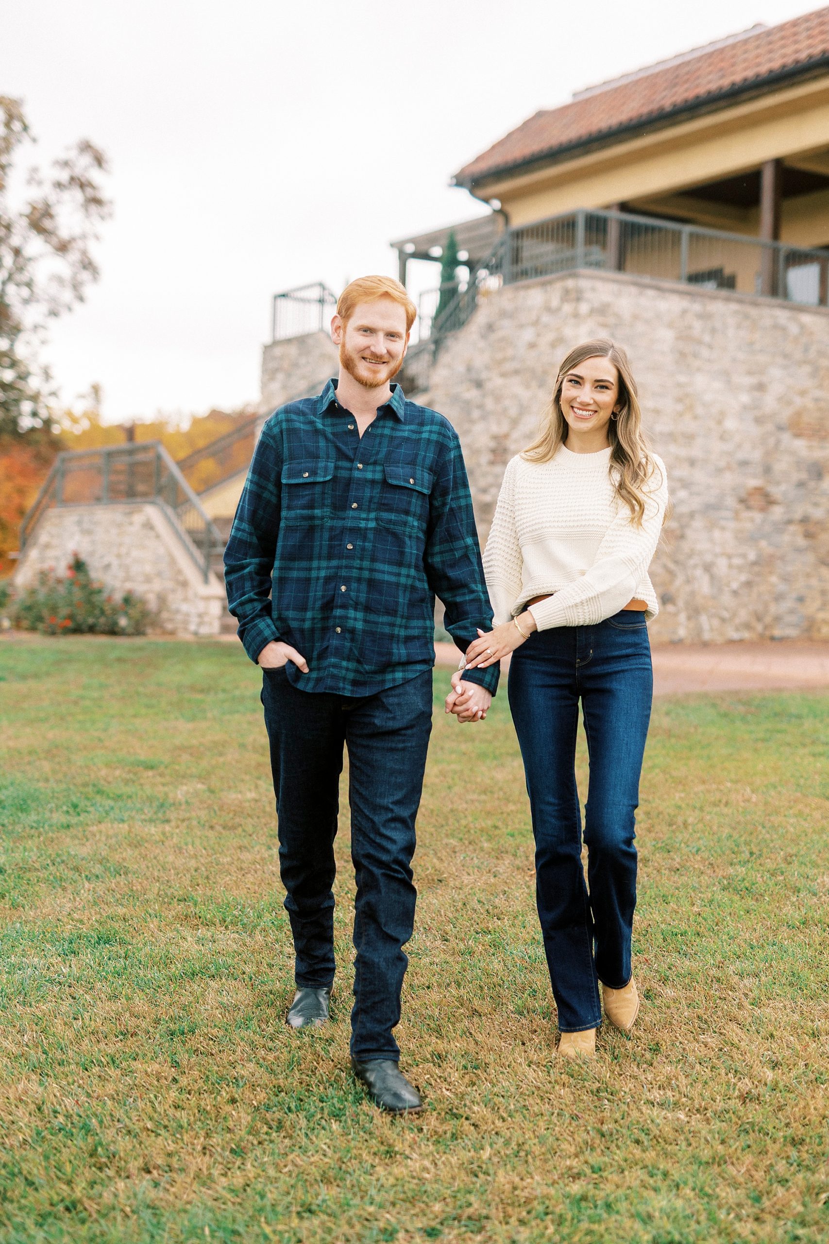 couple holds hands walking across courtyard at Raffaldini Vineyards