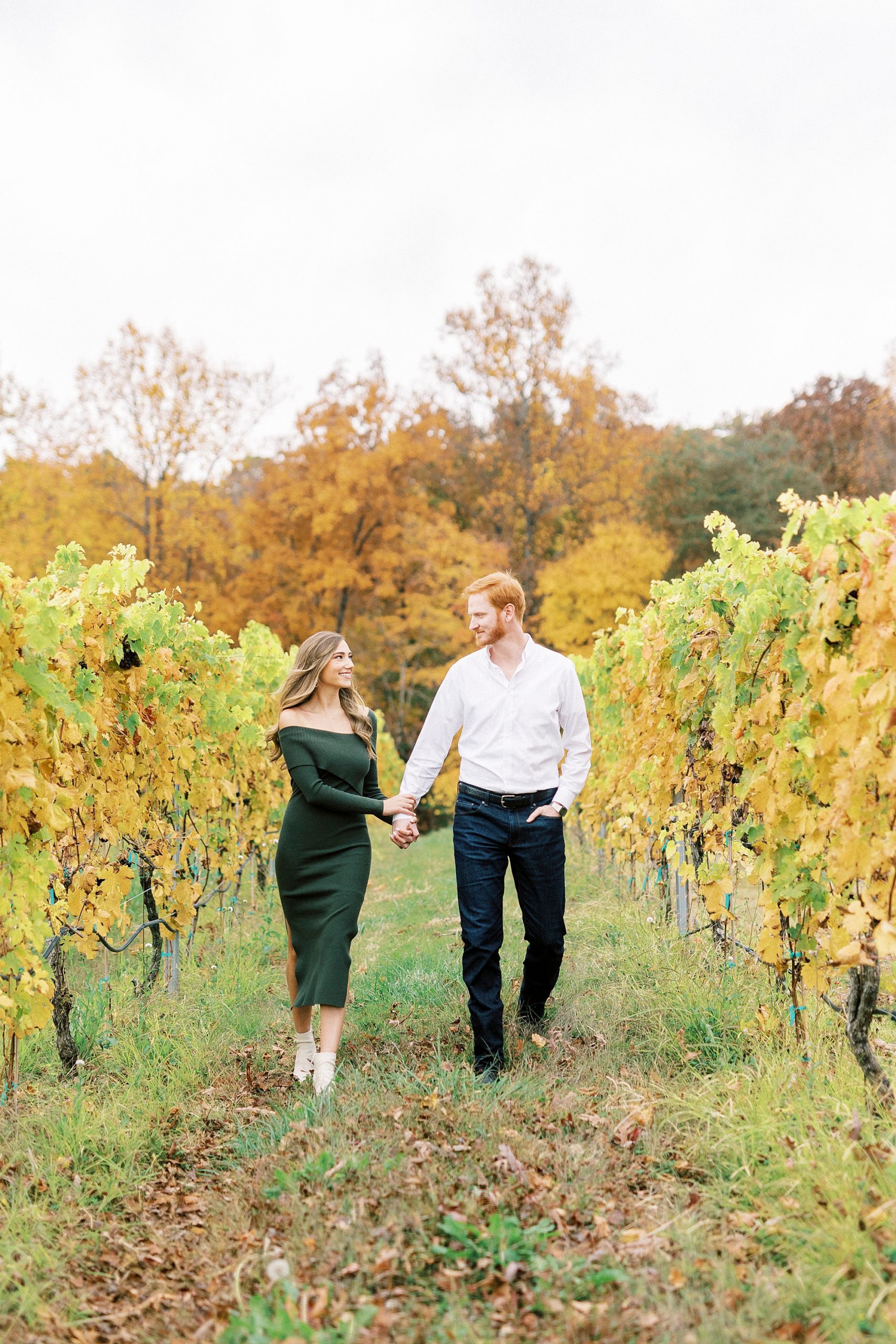 engaged couple holds hands walking around Raffaldini Vineyards