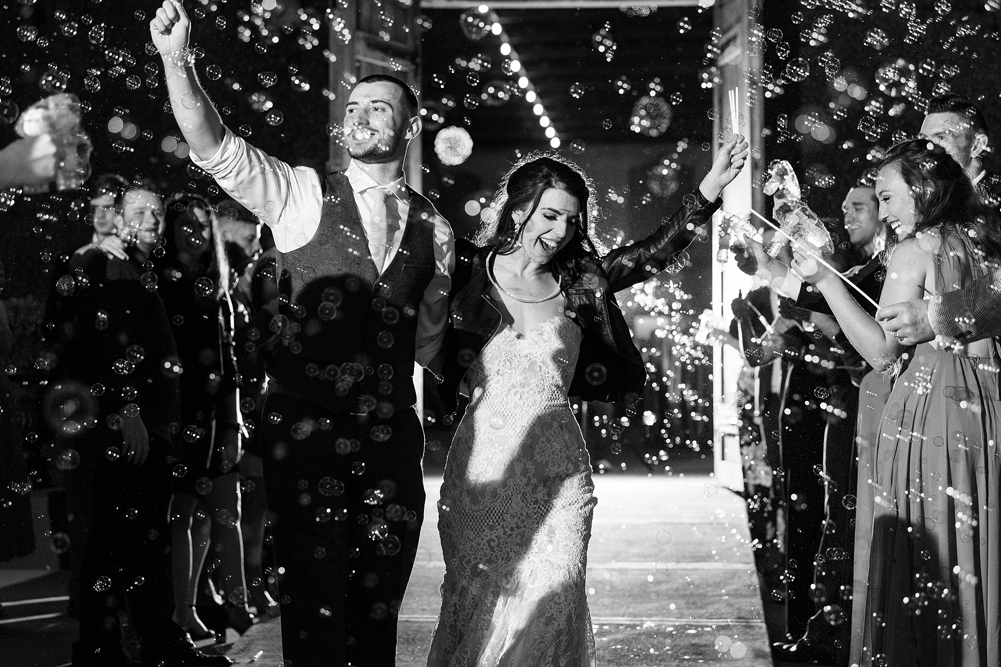 newlyweds cheer and wave during bubble exit on wedding day