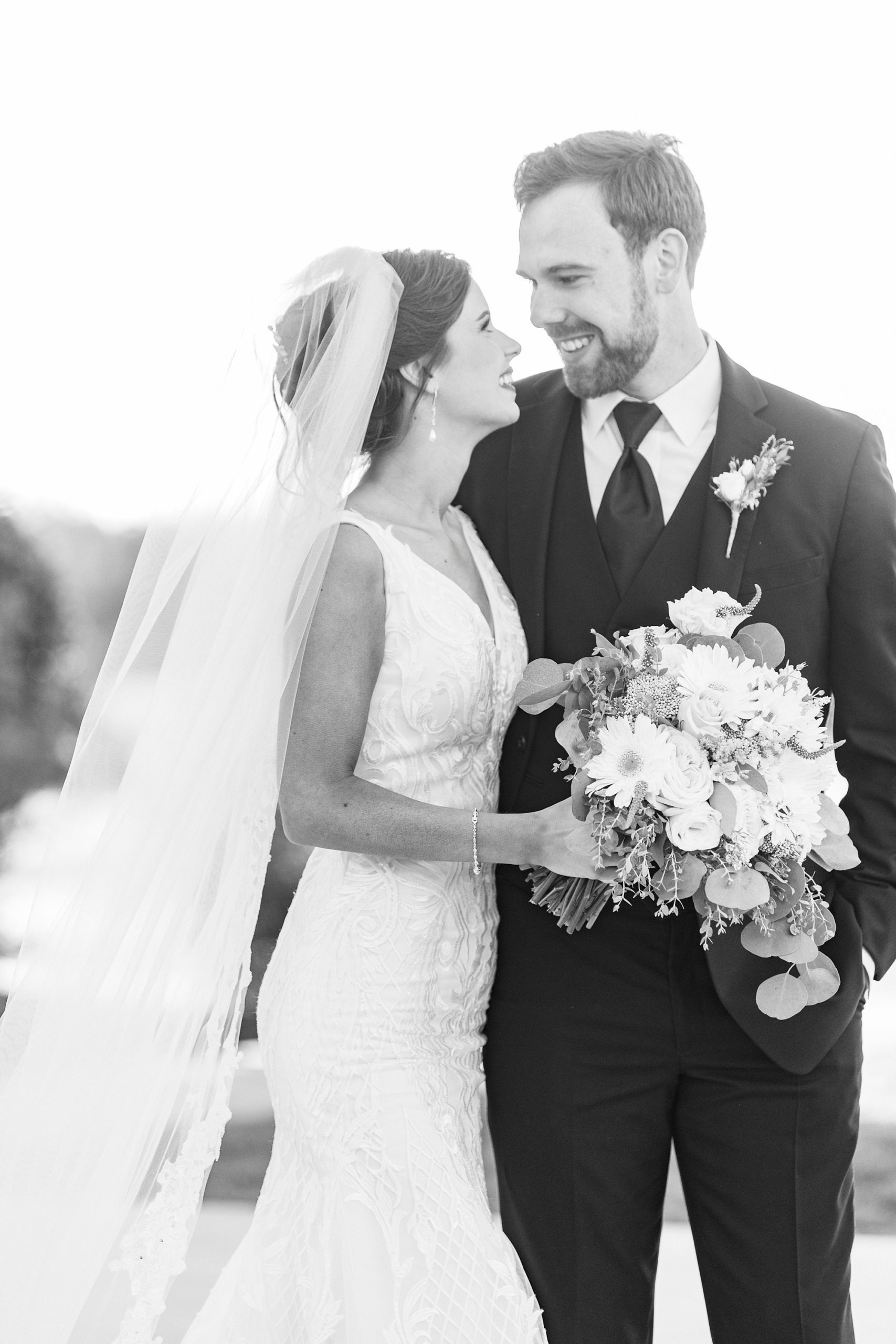 bride and groom smile hugging together on lawn at Chickadee Hill Farms