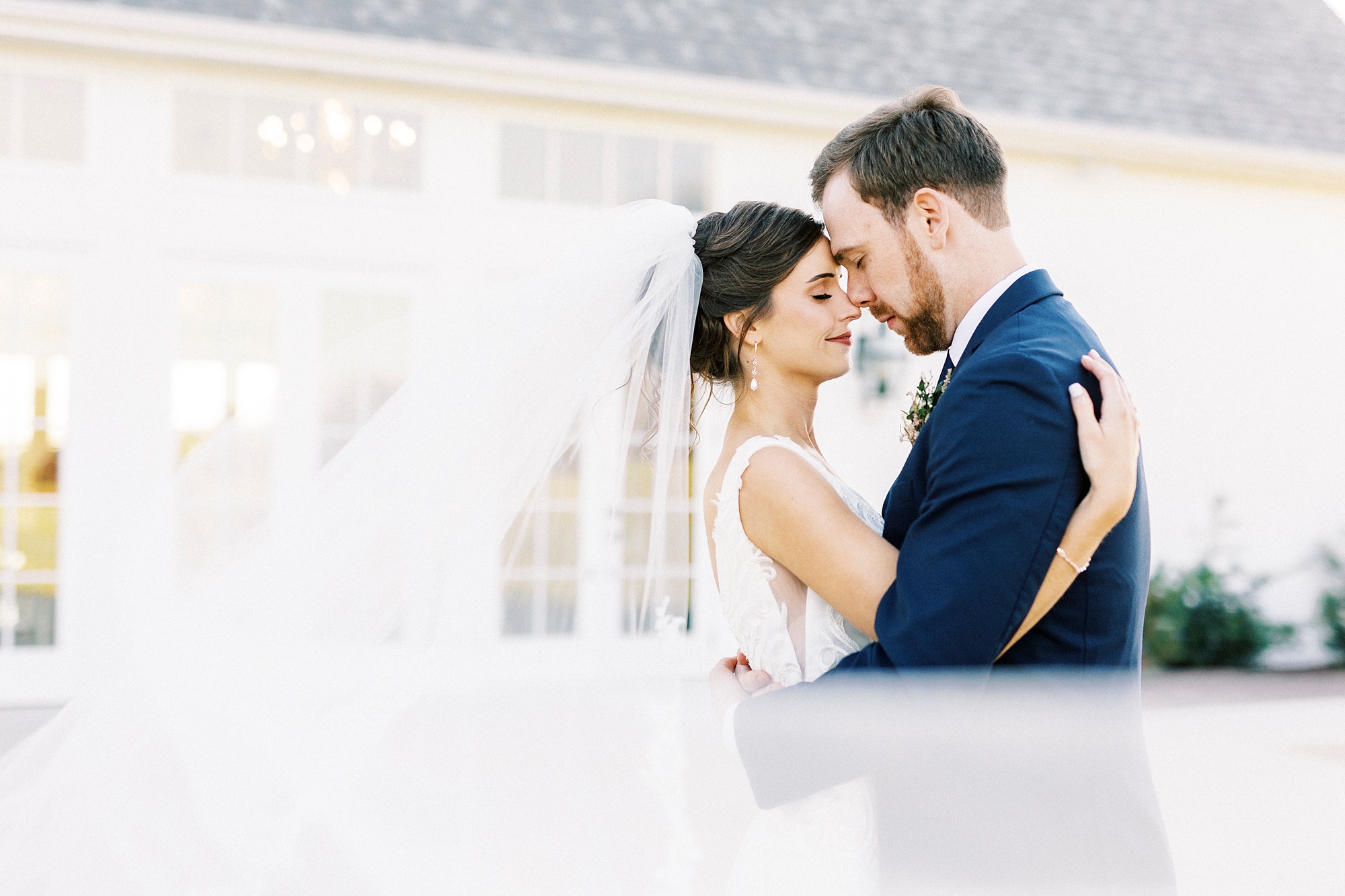 bride and groom hug with veil around them at Chickadee Hill Farms
