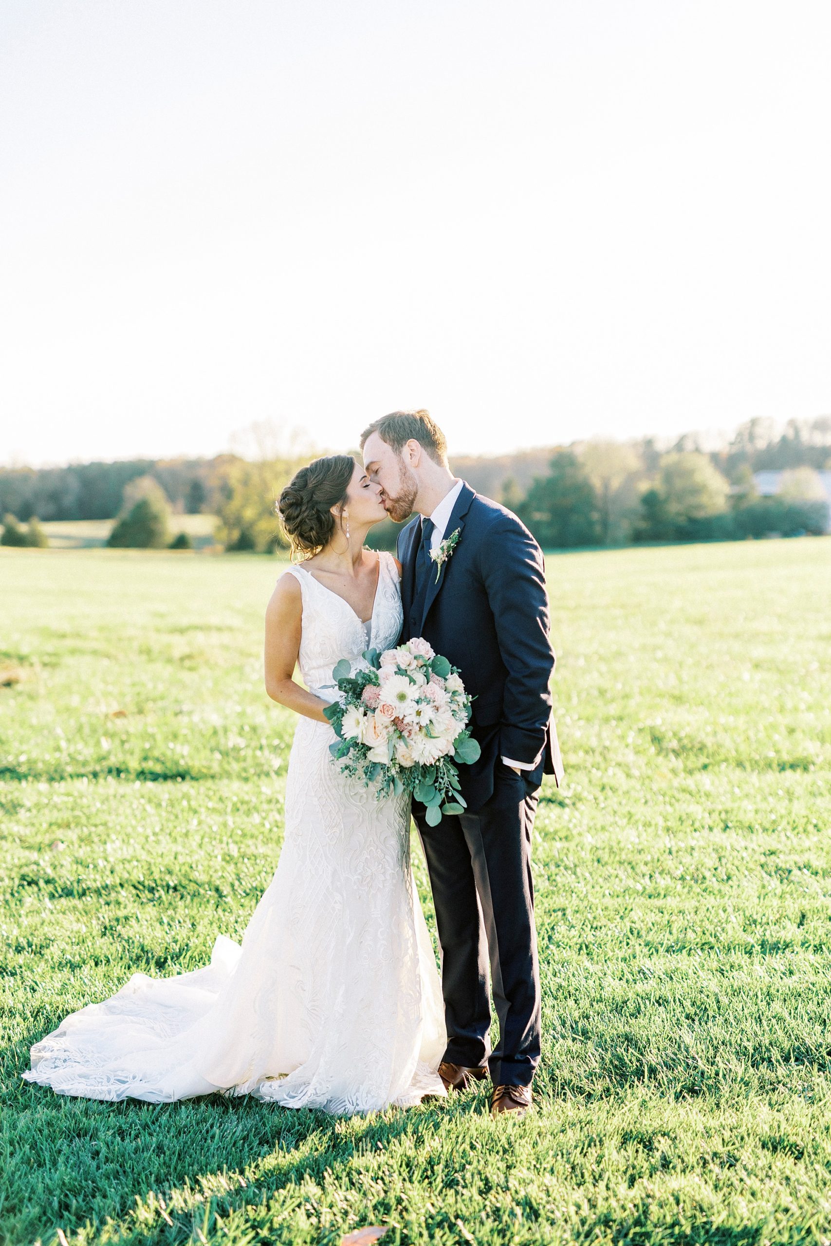 newlyweds kiss on lawn at Chickadee Hill Farms