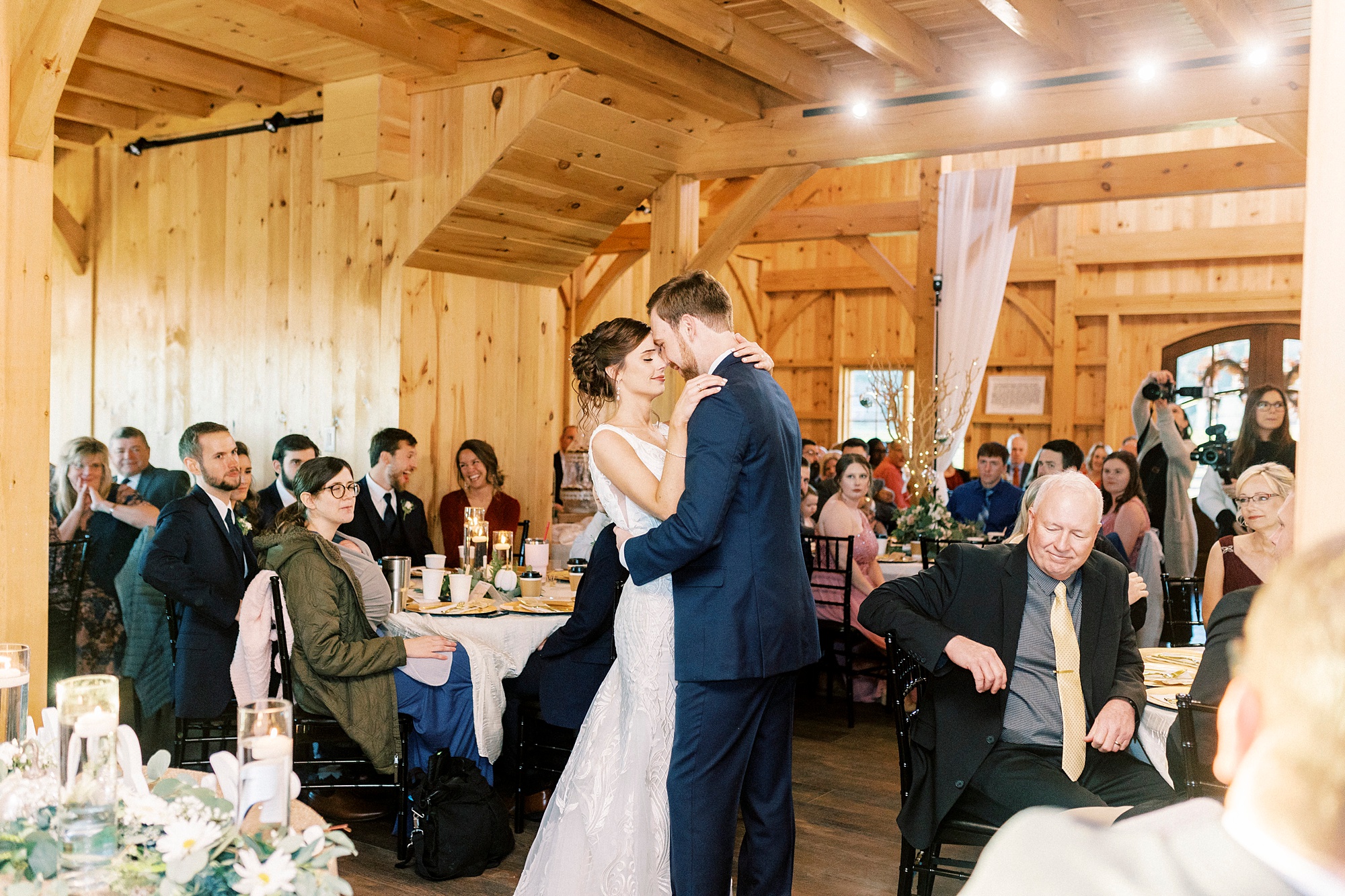 newlyweds dance in barn during first dance 
