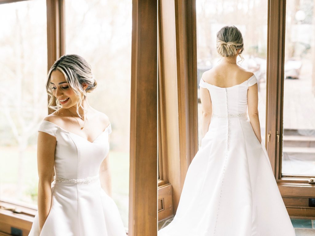 bride poses in off-the-shoulder wedding gown with pockets with classic updo