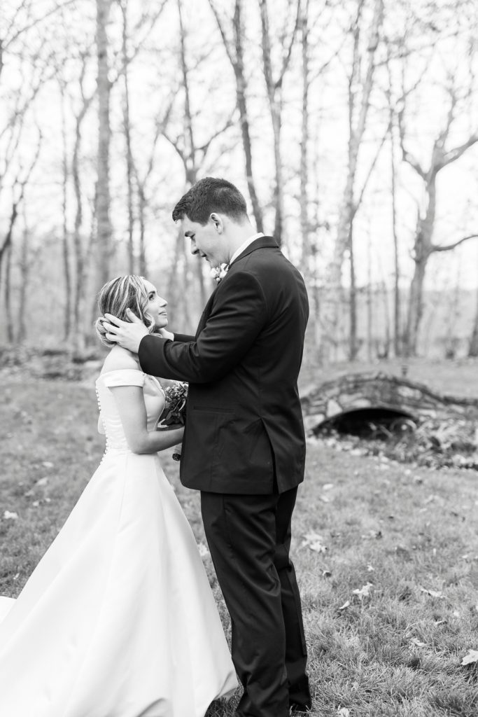 groom pushes stray hair back on bride's face during first look 
