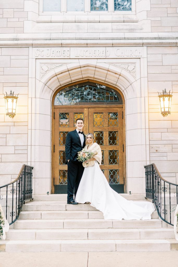 newlyweds stand hugging on steps at St. James Lutheran Church in Concord NC
