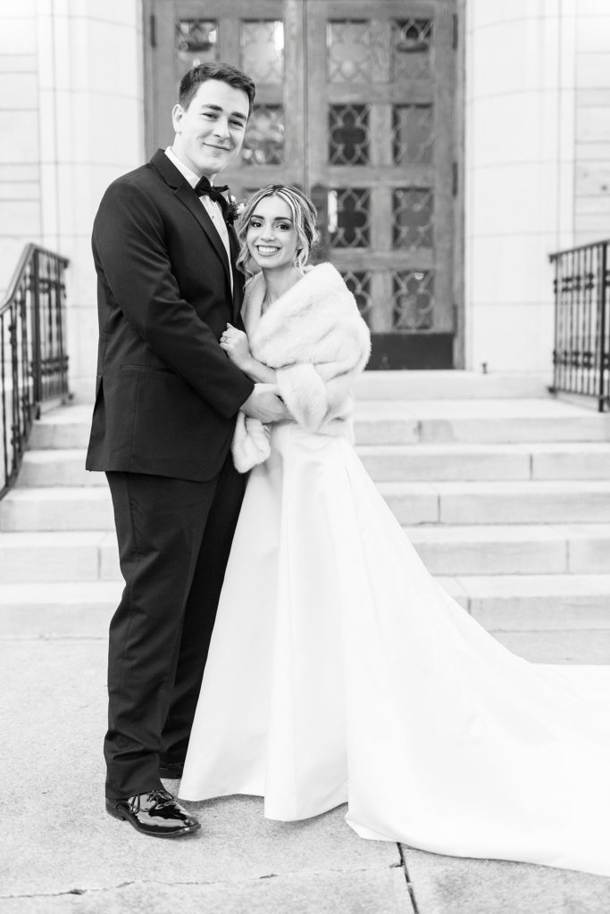 groom hugs bride to him during photos on steps at St. James Lutheran Church in Concord NC
