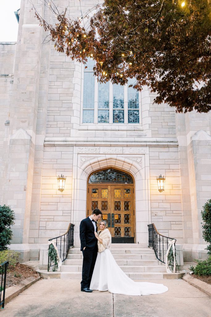 groom leans down to kiss bride's forehead during portraits outside St. James Lutheran Church in Concord NC