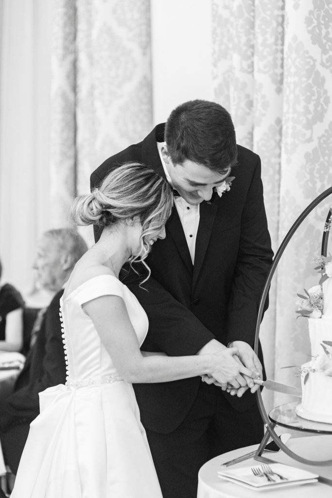 bride and groom cut wedding cake during the Hotel Concord wedding reception 