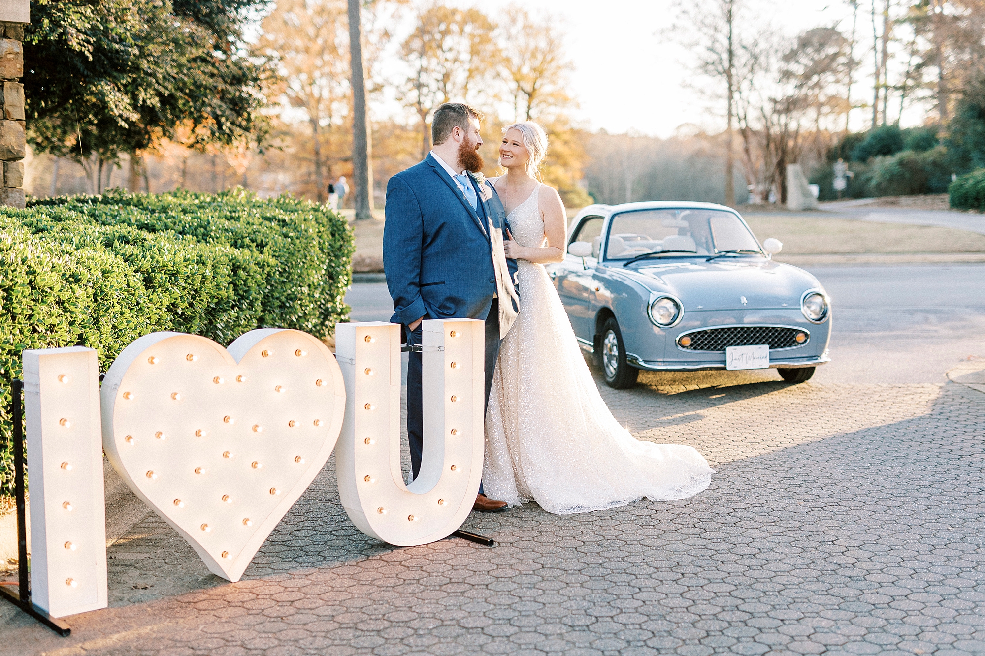 bride and groom hug by marquee lights with "I heart you" by Charlotte the Figgy