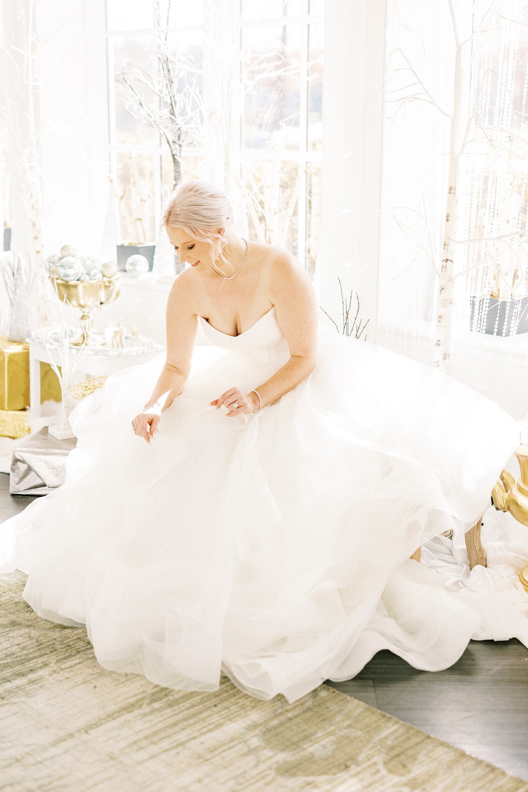 bride adjusts wedding gown during winter wonderland wedding at River Run Country Club