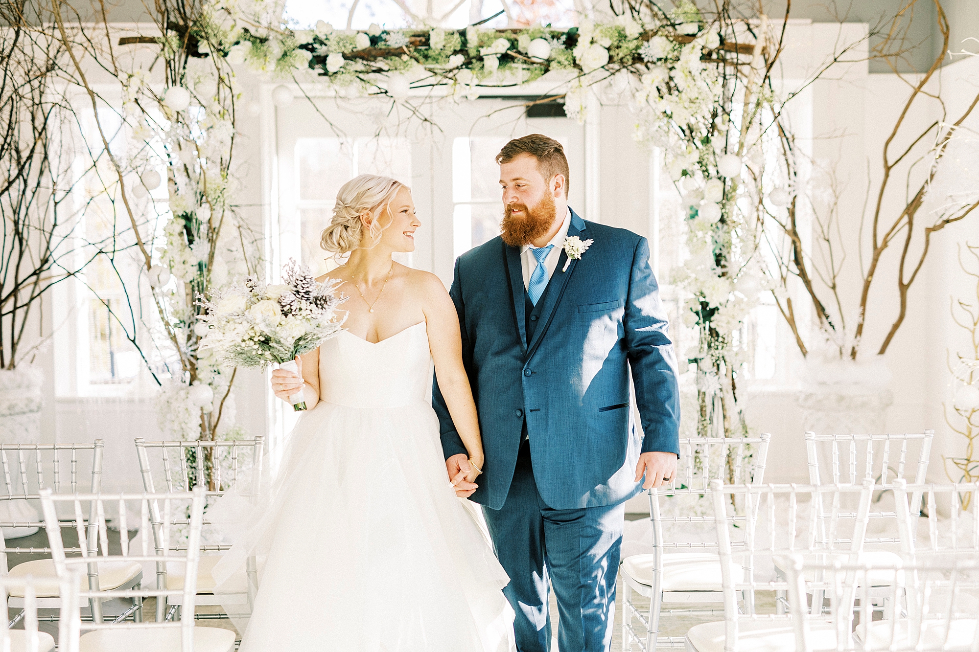 bride and groom holds ands walking up aisle at River Run Country Club