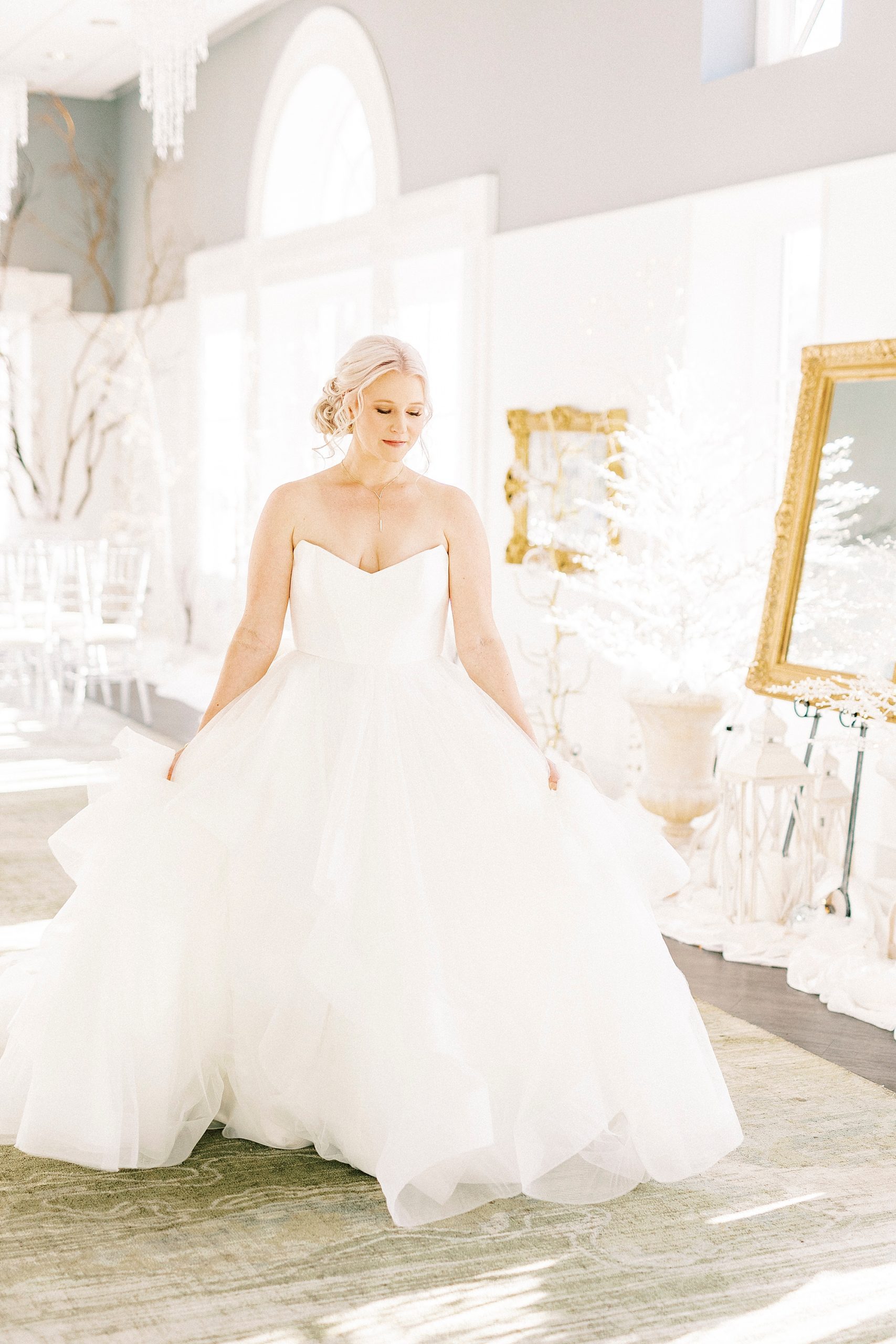 bride shows off skirt of strapless wedding gown