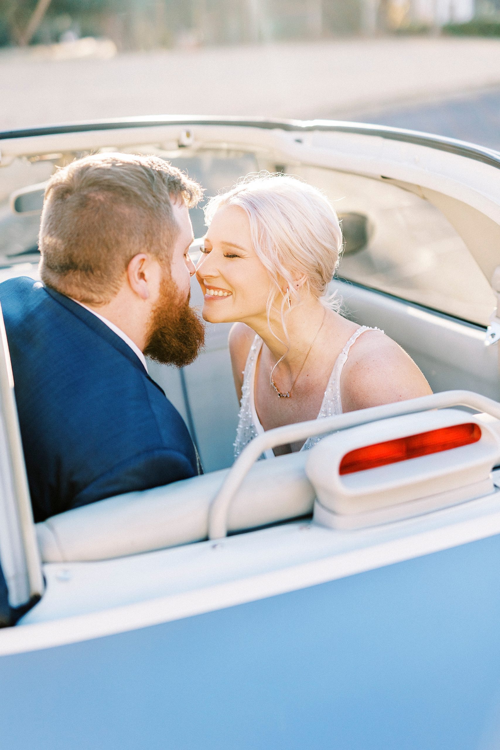 bride and groom lean in to kiss in back of Charlotte the Figgy