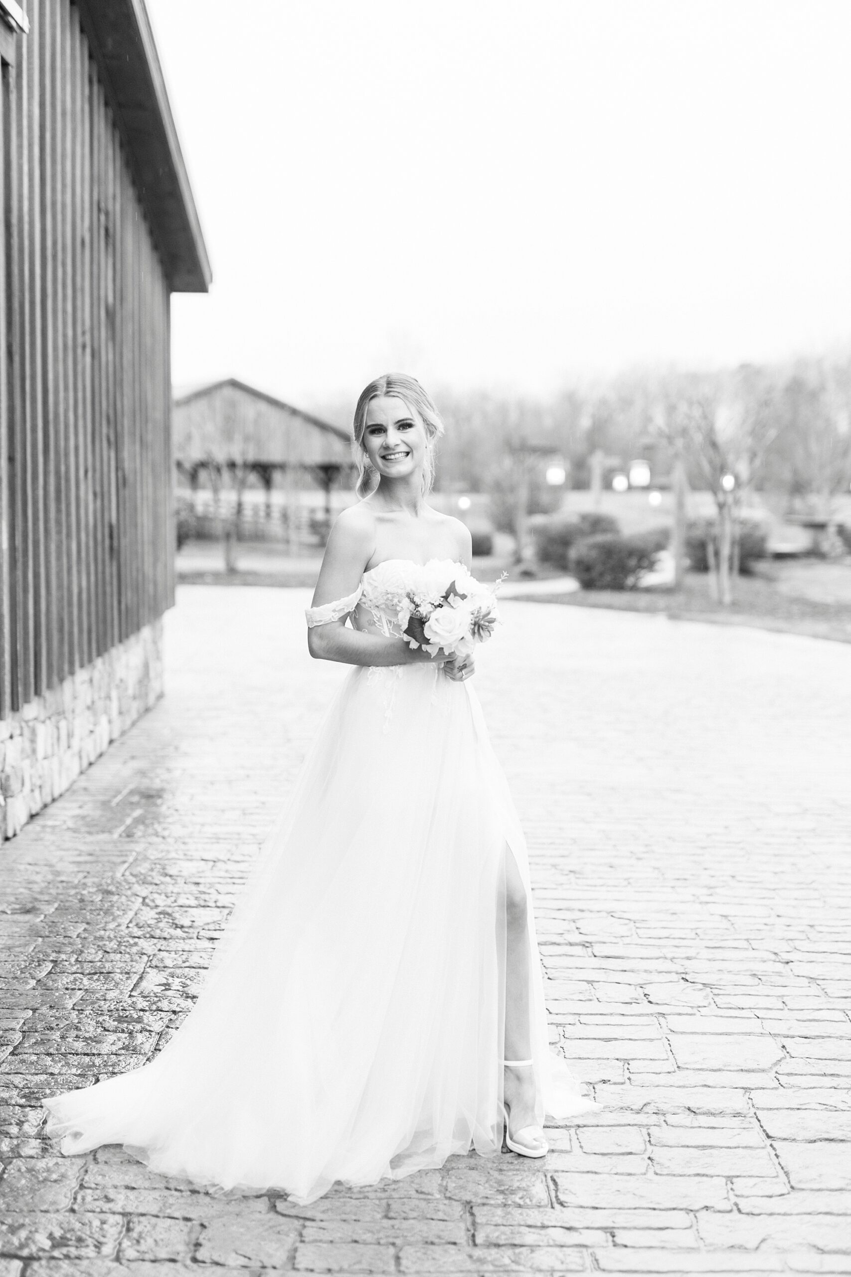 black and white portrait of bride laughing looking over shoulder in wedding gown 
