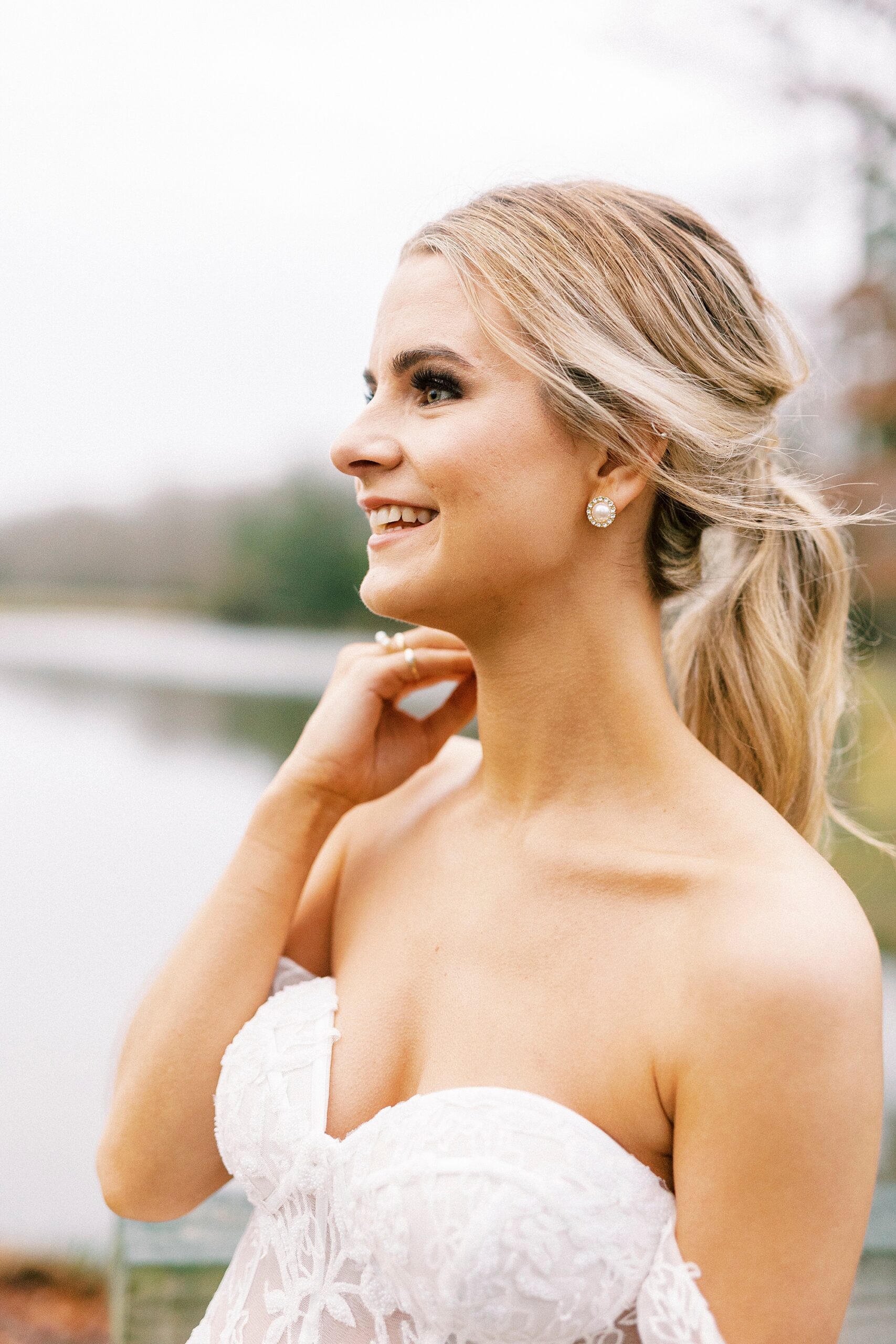 blonde bride smiles looking at lake