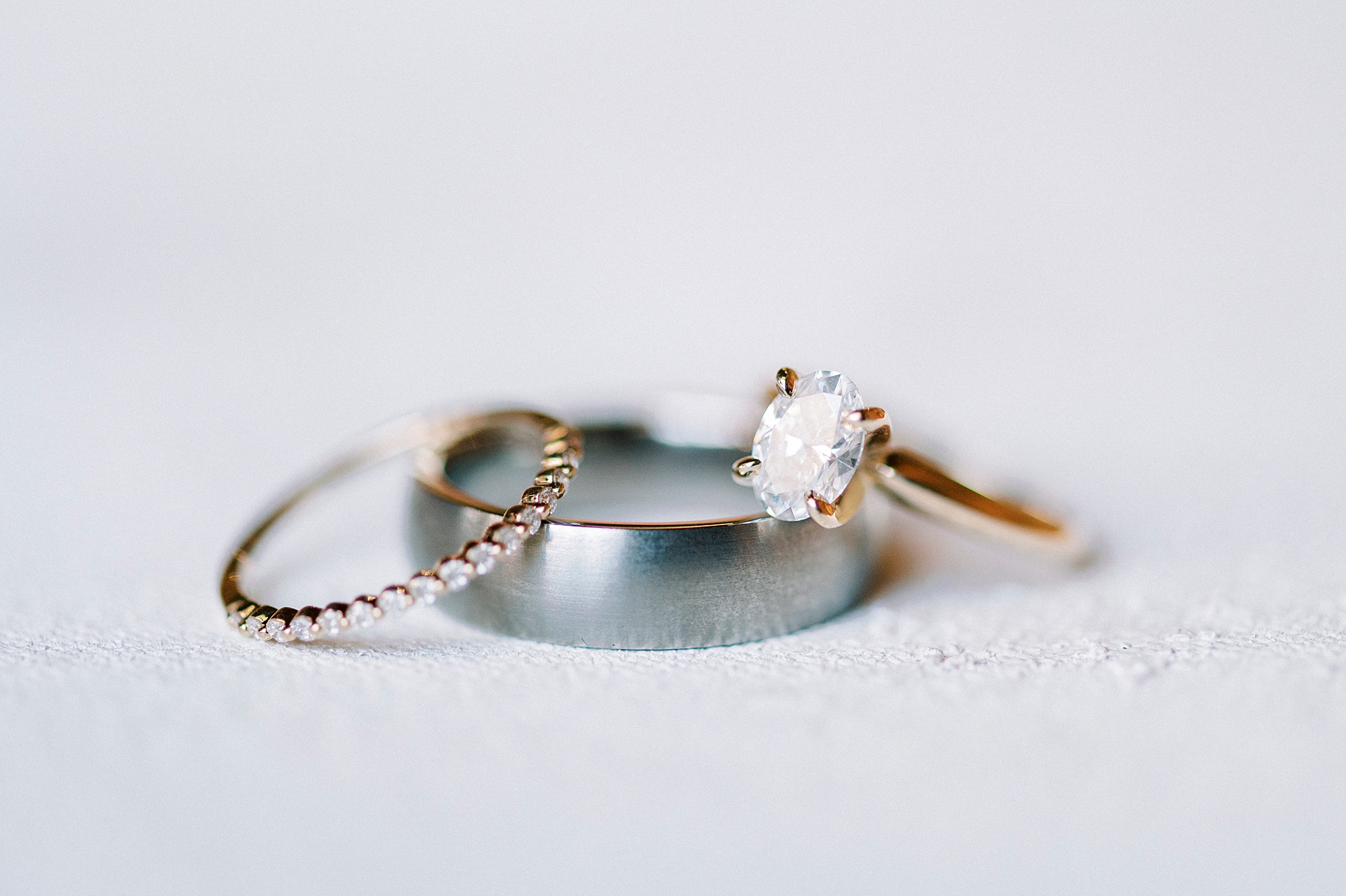 wedding bands lay on ivory backdrop 