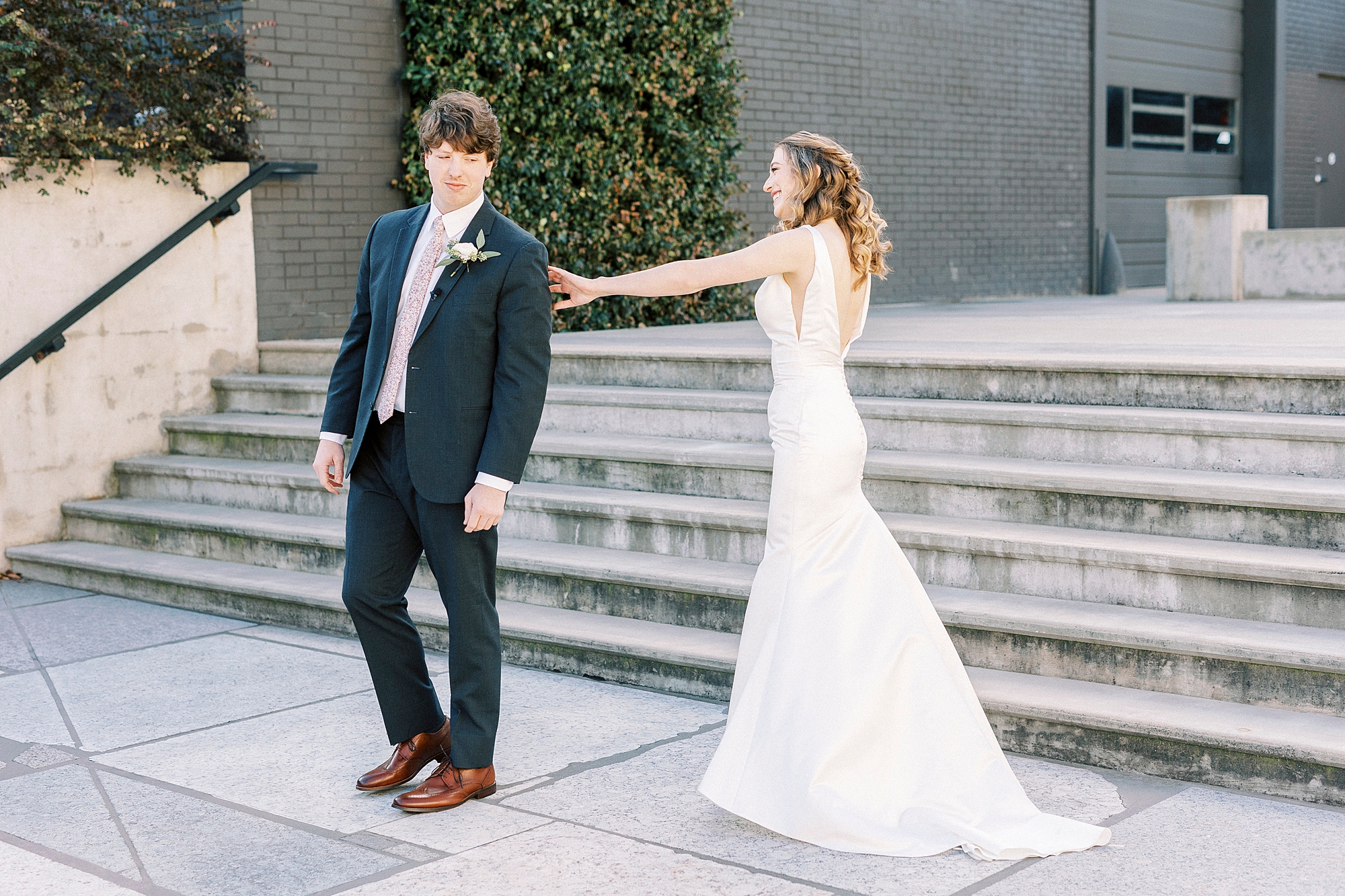 bride reaches for groom during first look 