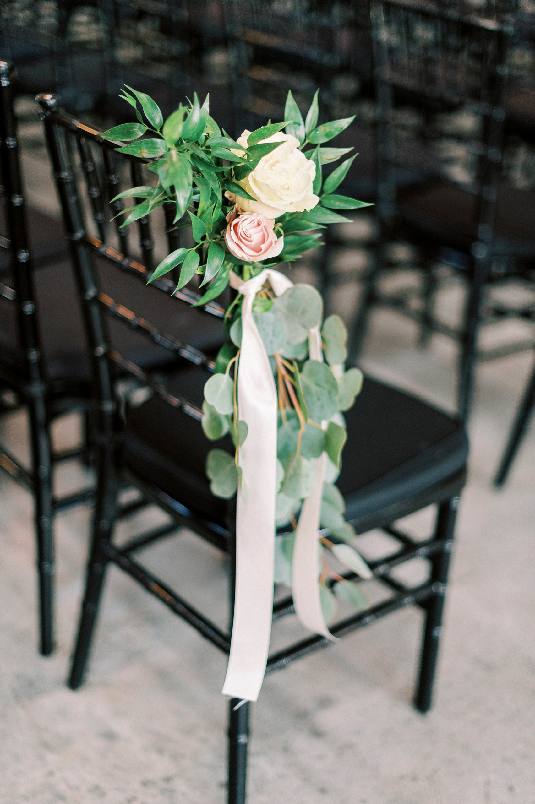 white rose floral accents on chairs for the Cadillac Service Garage ceremony 