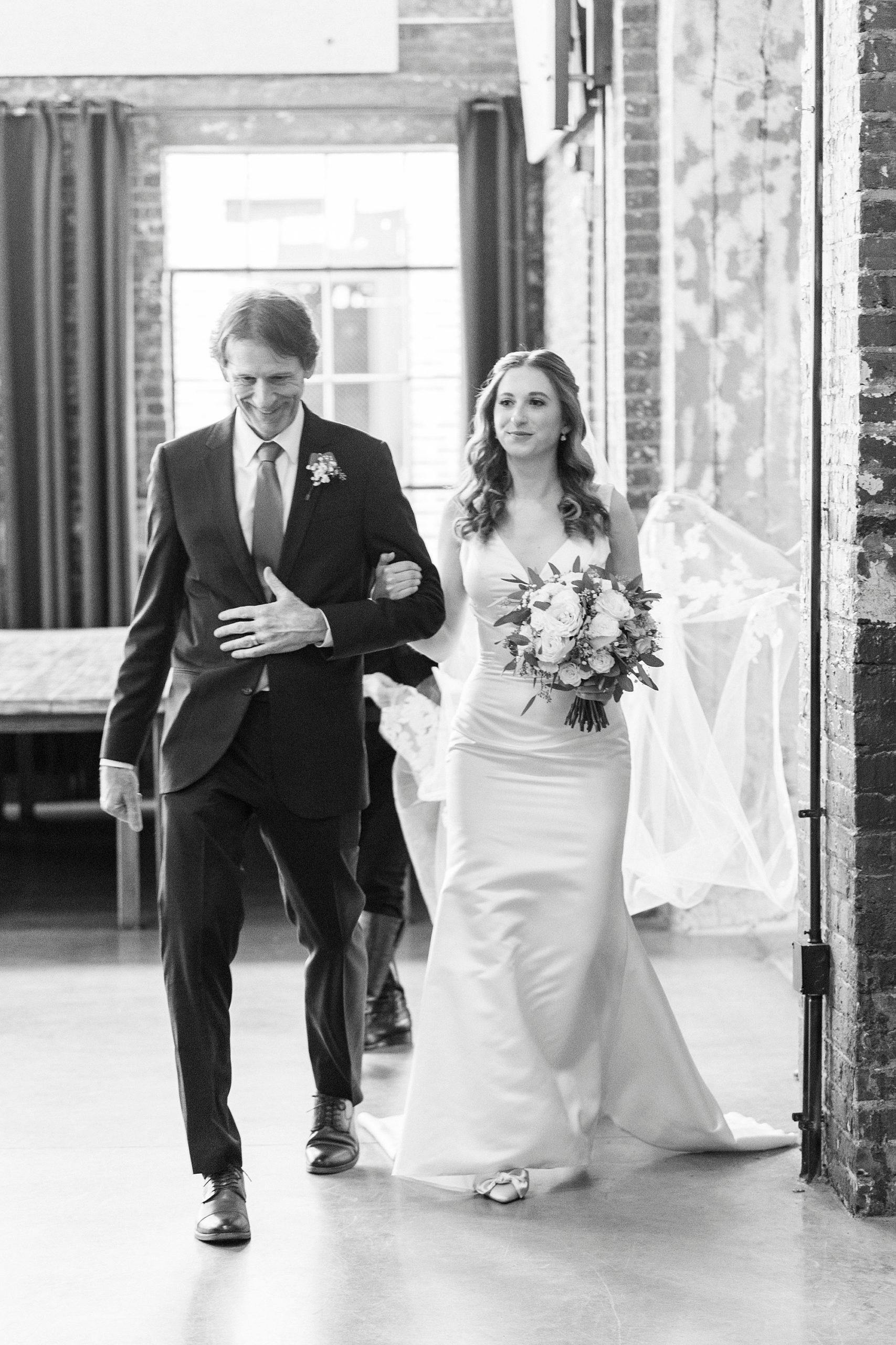 bride walks into wedding ceremony at the Cadillac Service Garage