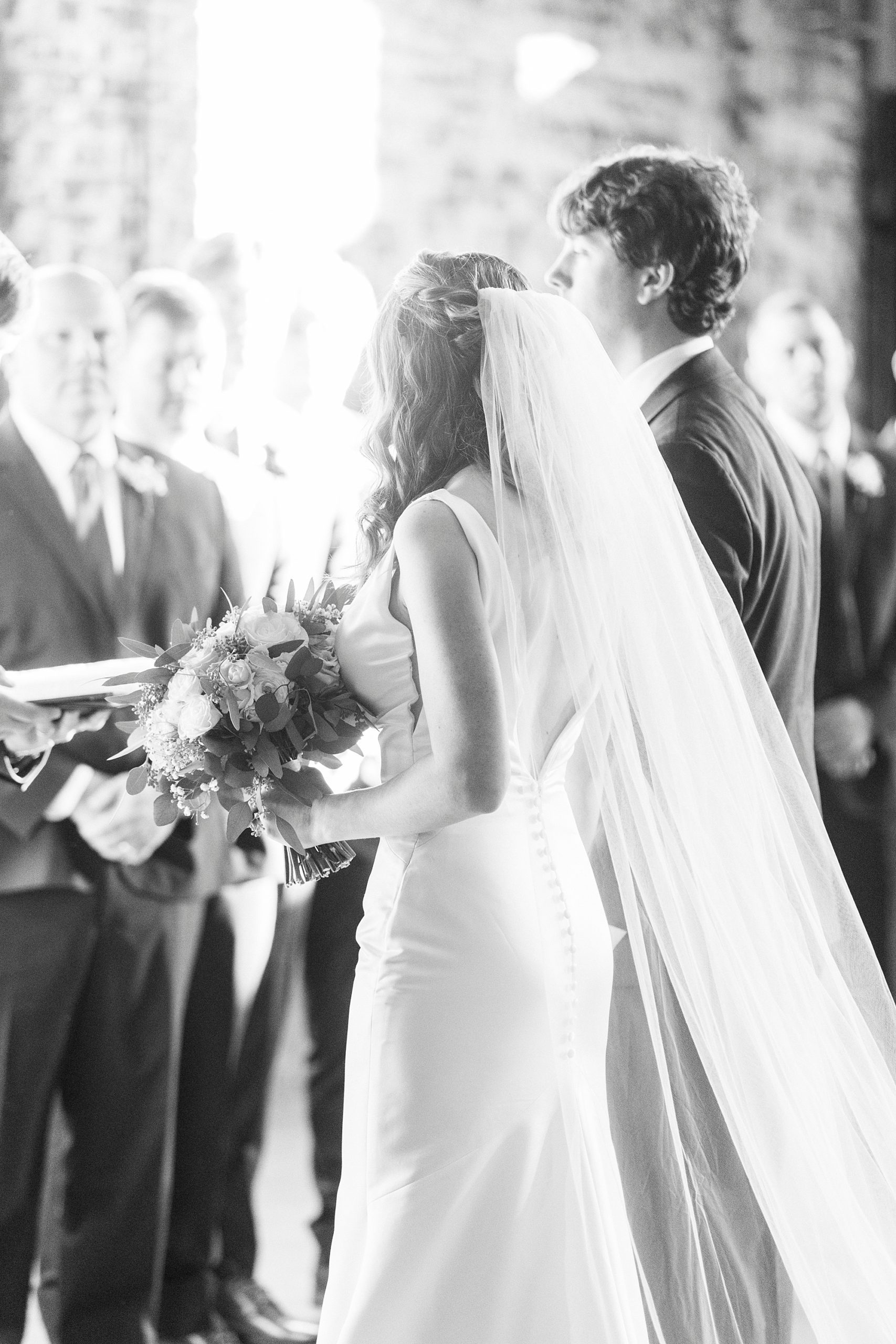 bride and groom stand together before Christ-centered wedding ceremony at the Cadillac Service Garage in Greensboro NC