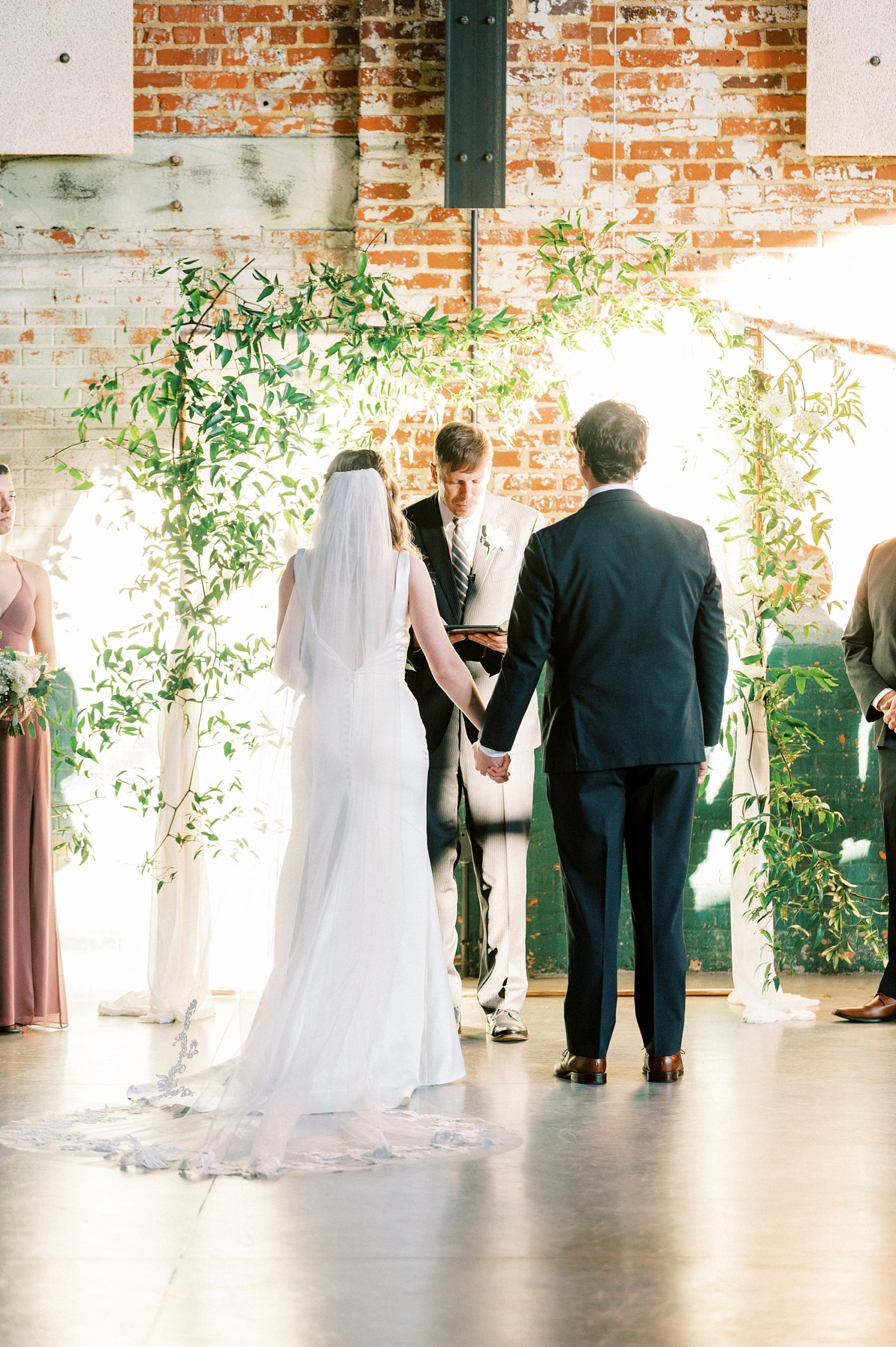 newlyweds hold hands for Christ-centered wedding ceremony at the Cadillac Service Garage in Greensboro NC