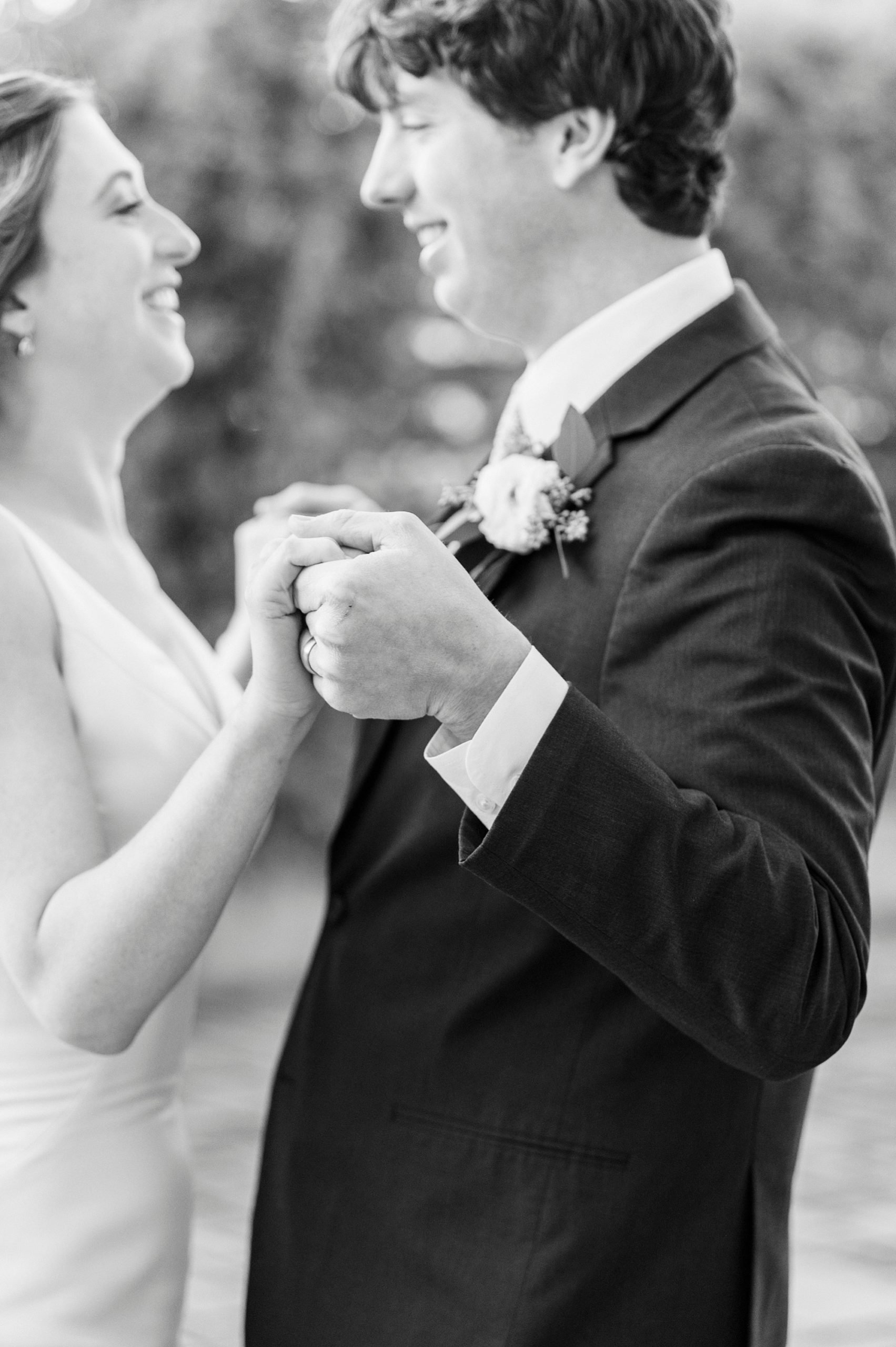 brie and groom hold hands during portraits at the Cadillac Service Garage