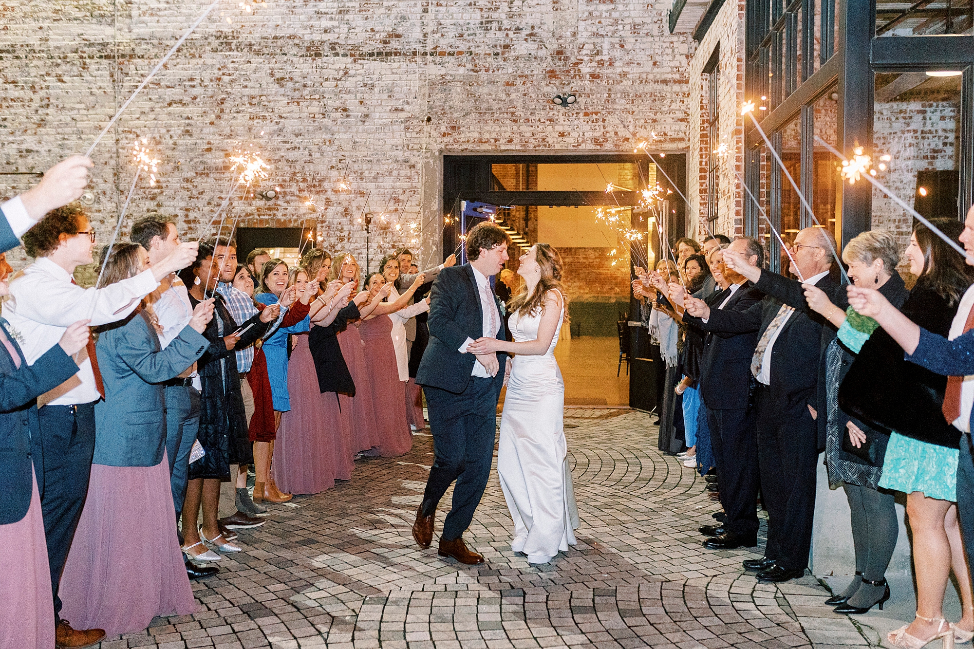 newlyweds kiss leaving the Cadillac Service Garage during sparkler exit