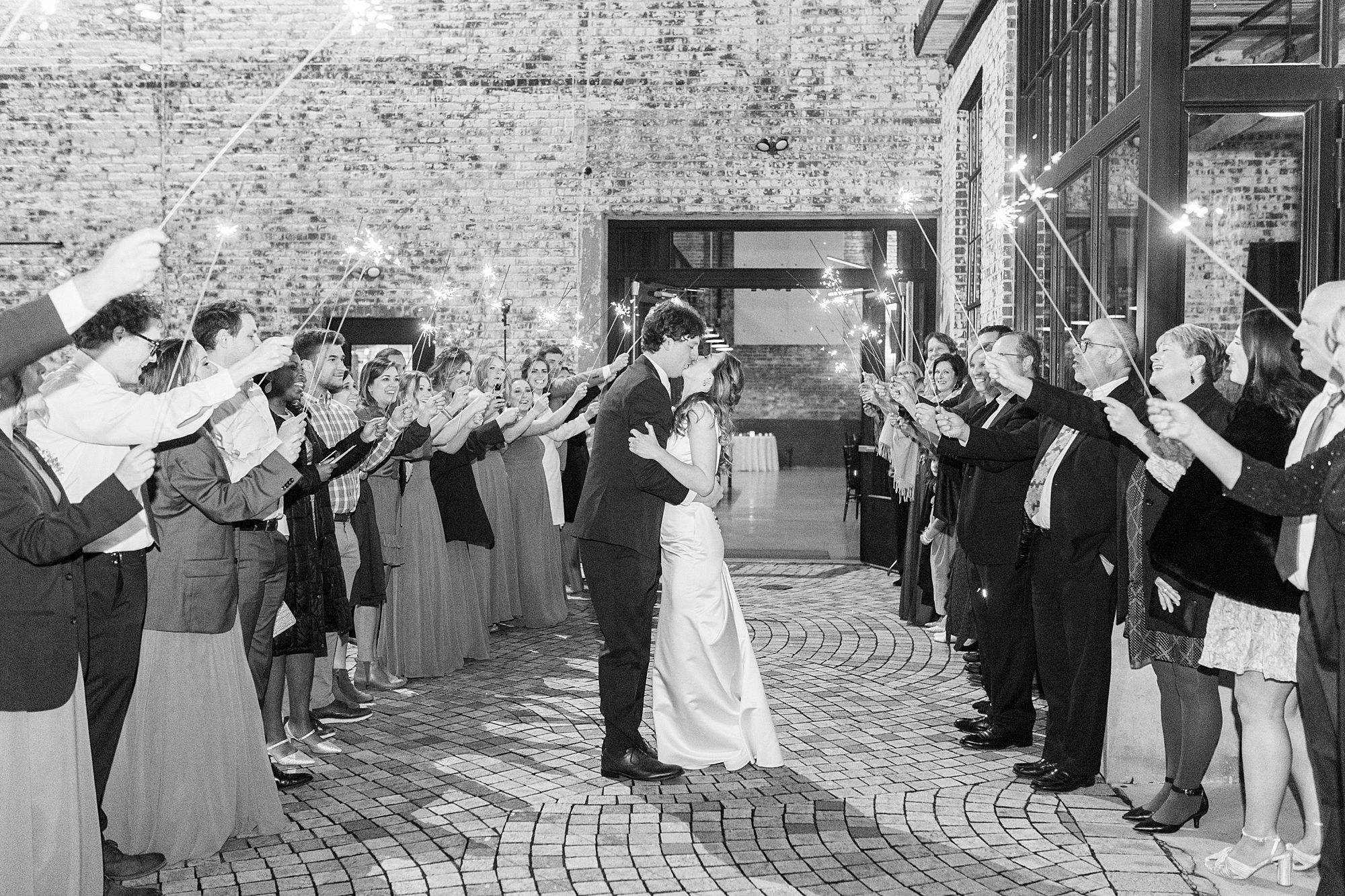 newlyweds kiss leaving the Cadillac Service Garage during sparkler exit