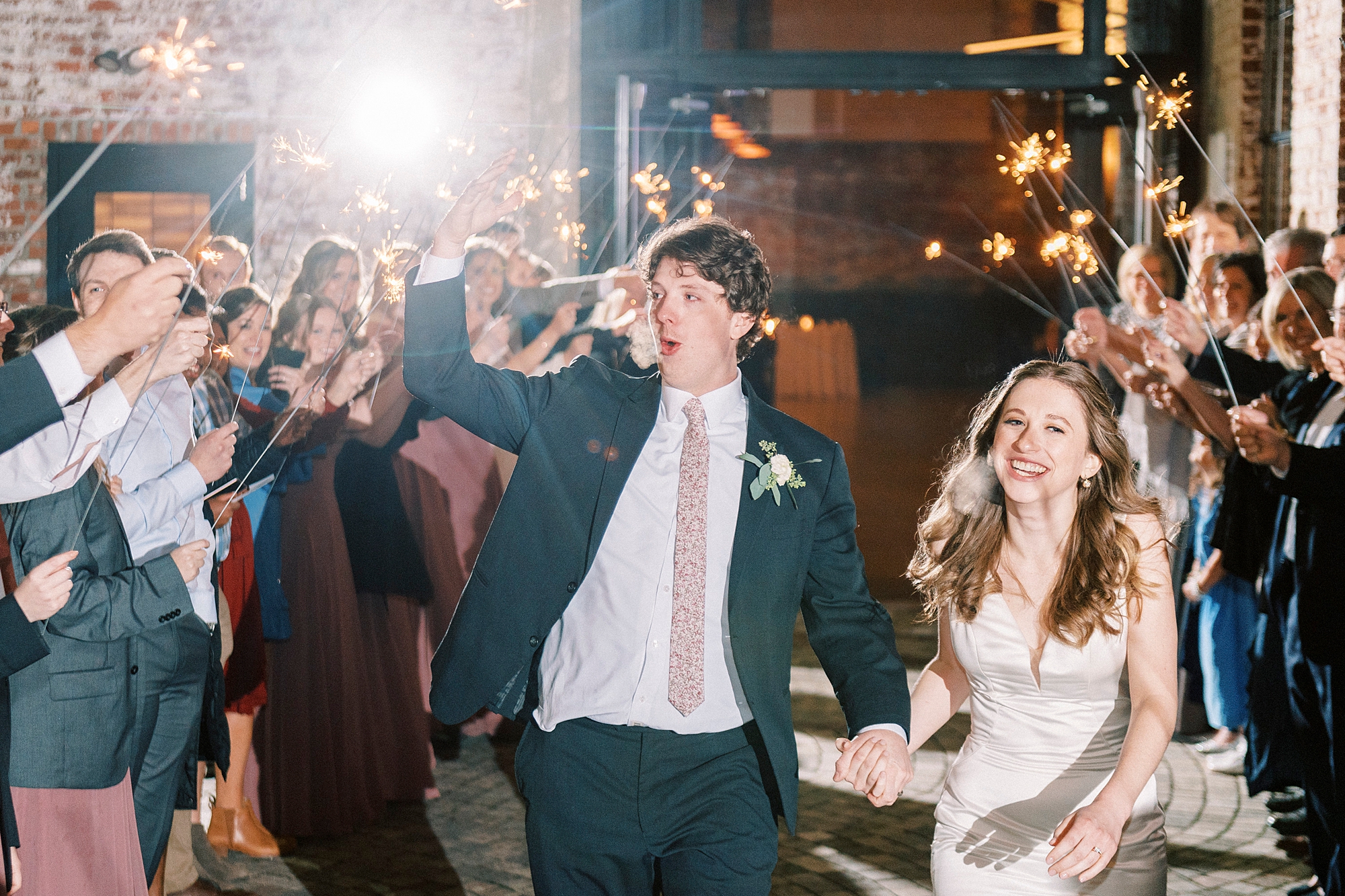 newlyweds cheer leaving the Cadillac Service Garage during sparkler exit