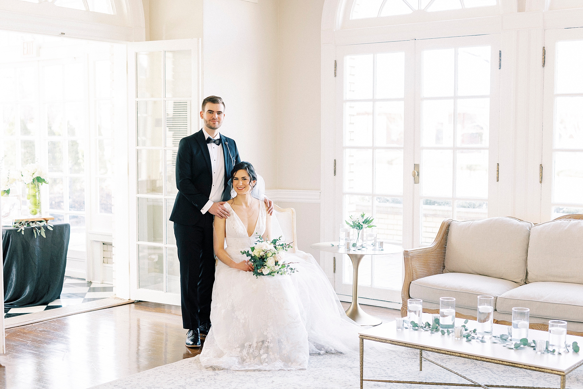 bride sits in chair with groom behind her at Separk Mansion