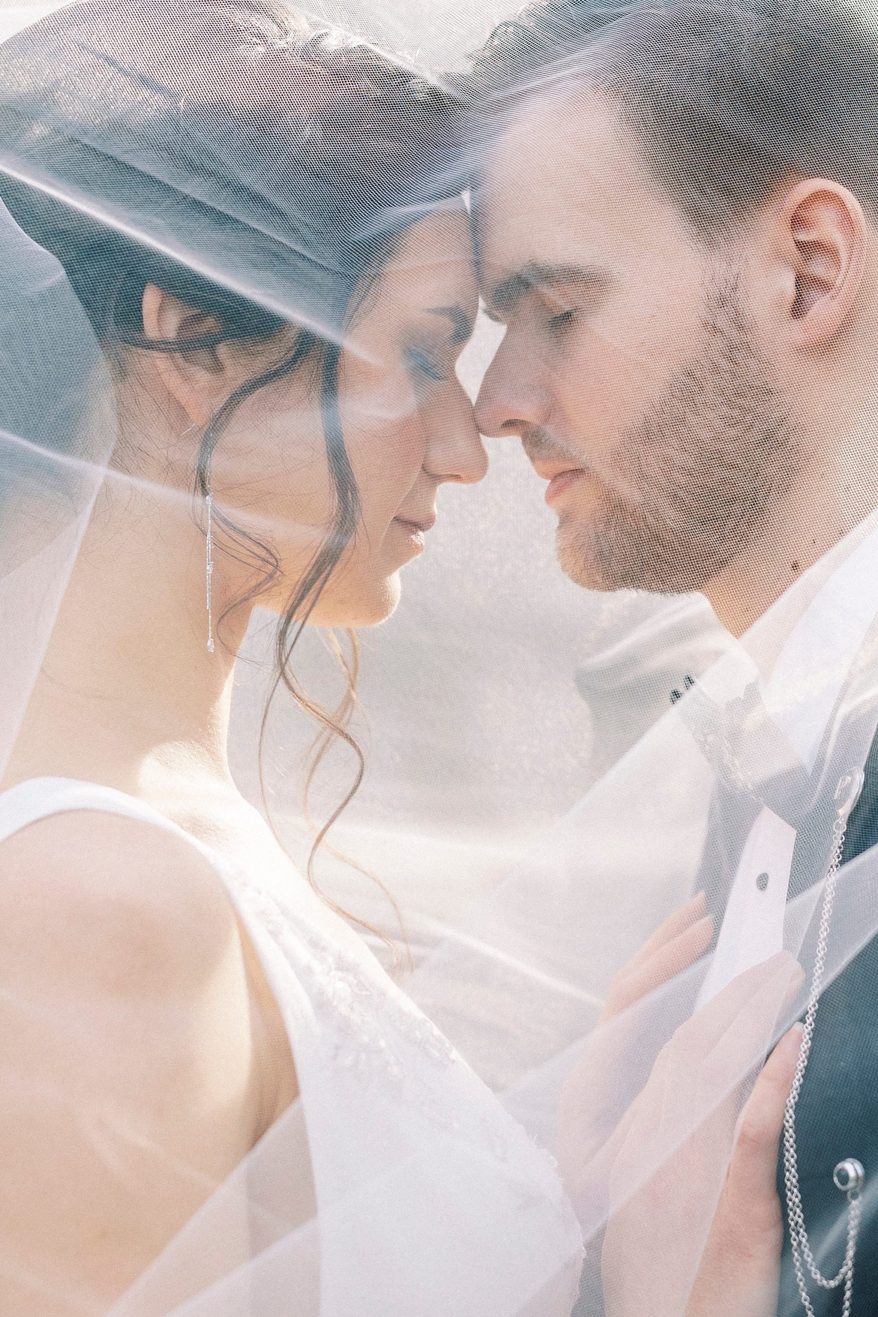 bride and groom hug under bride's veil 