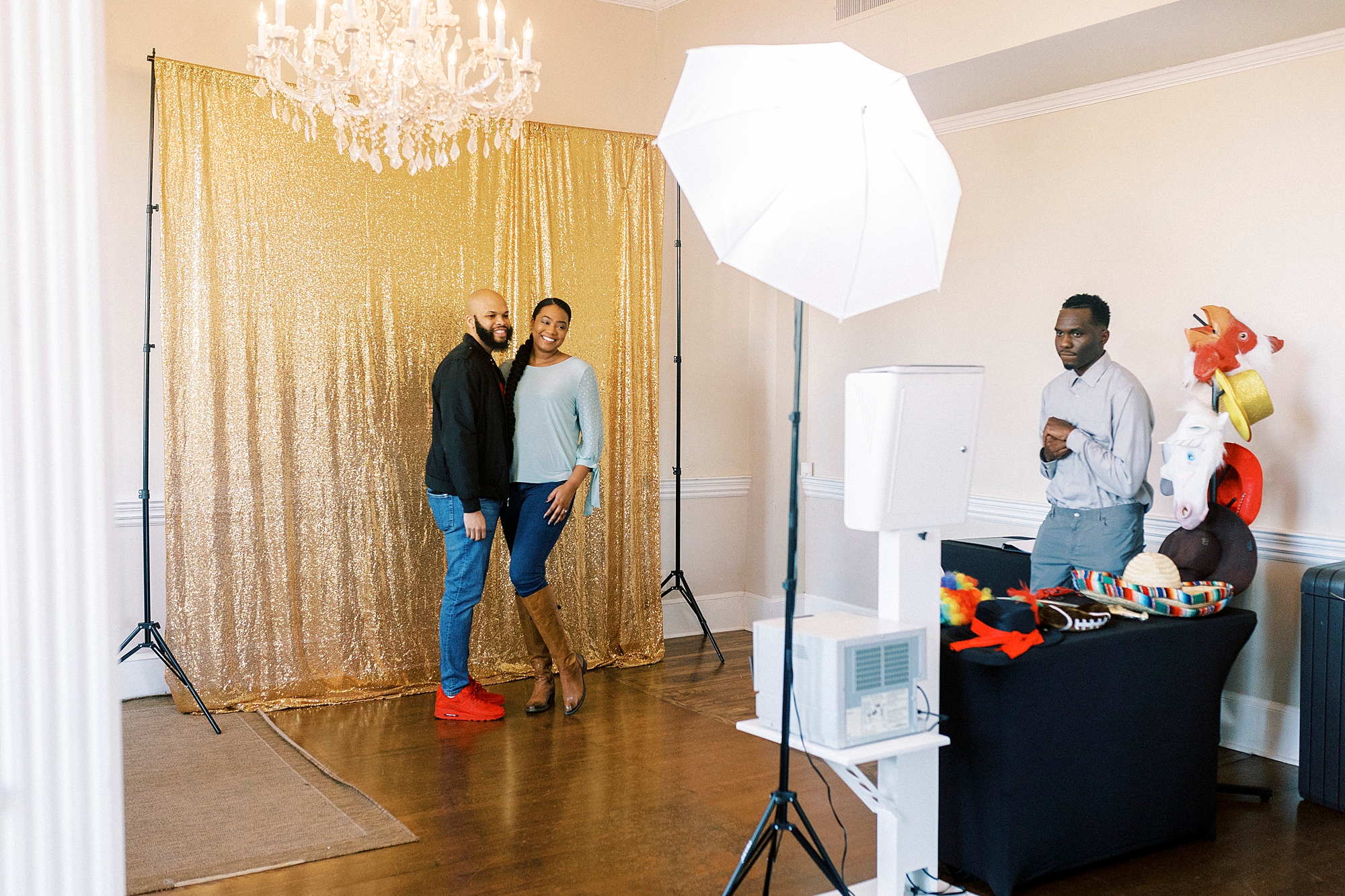 couple poses in front of gold sequined Photo Booth backdrop 