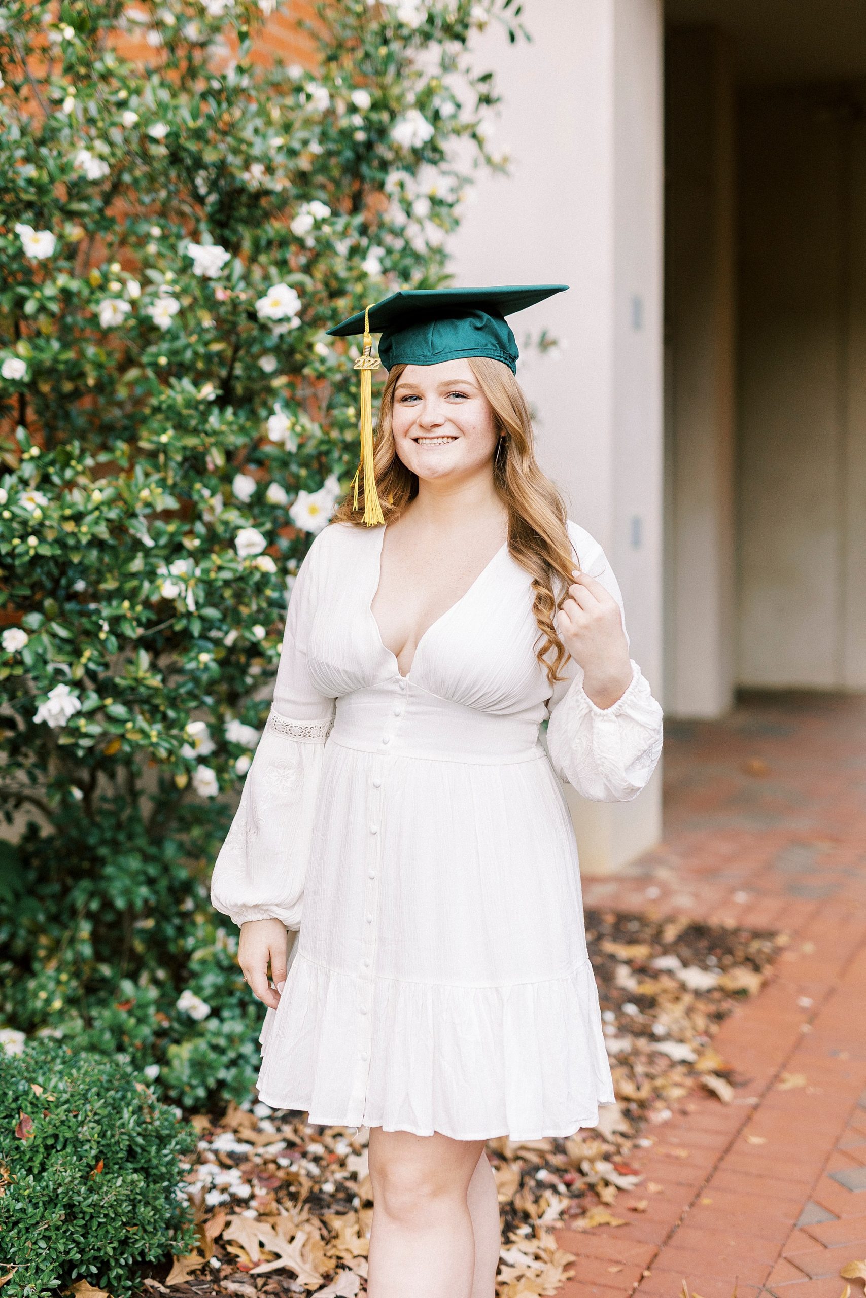 woman twirls hair during florals outside UNC Charlotte building