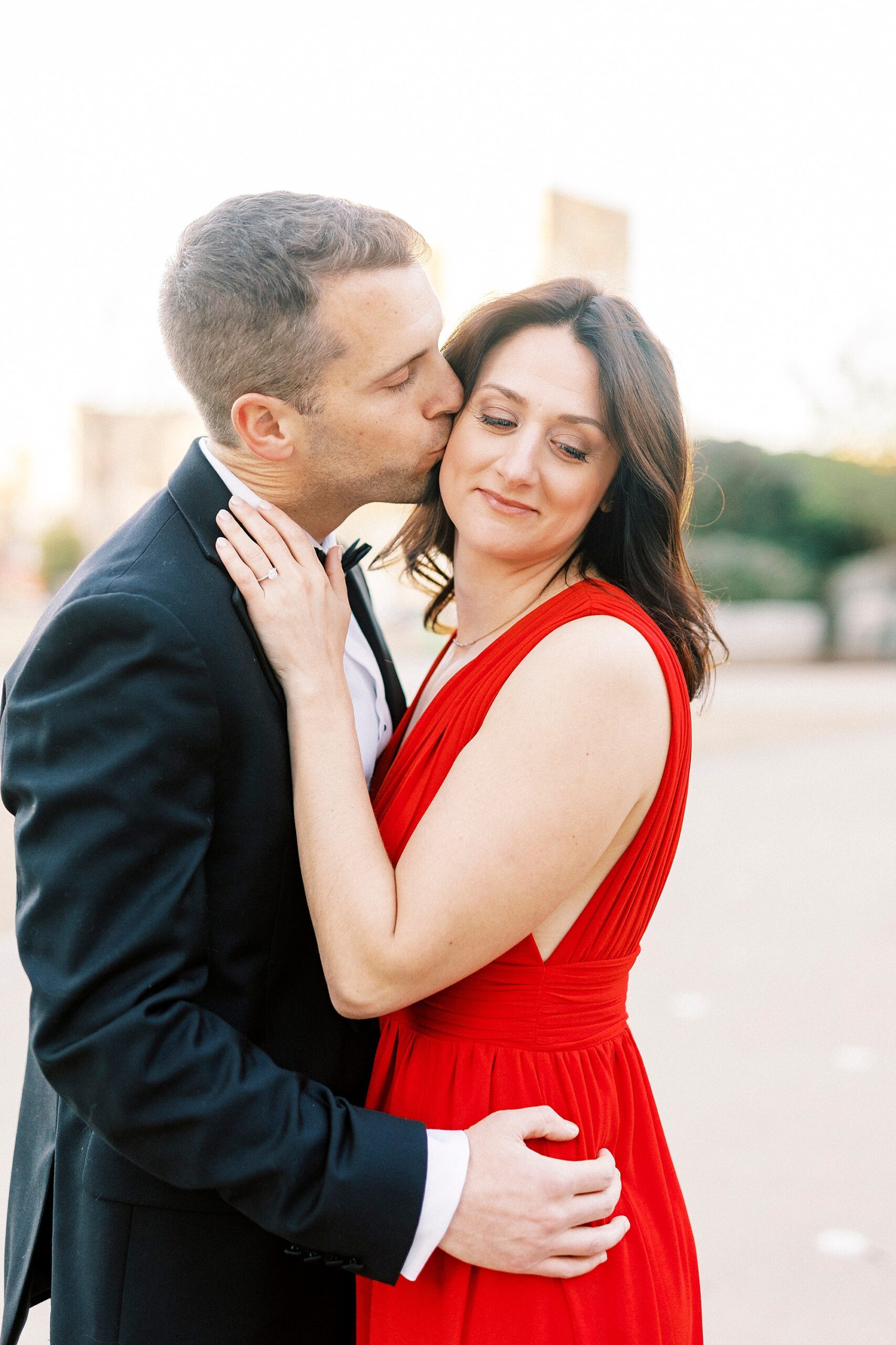 man kisses woman's cheek hugging her to him