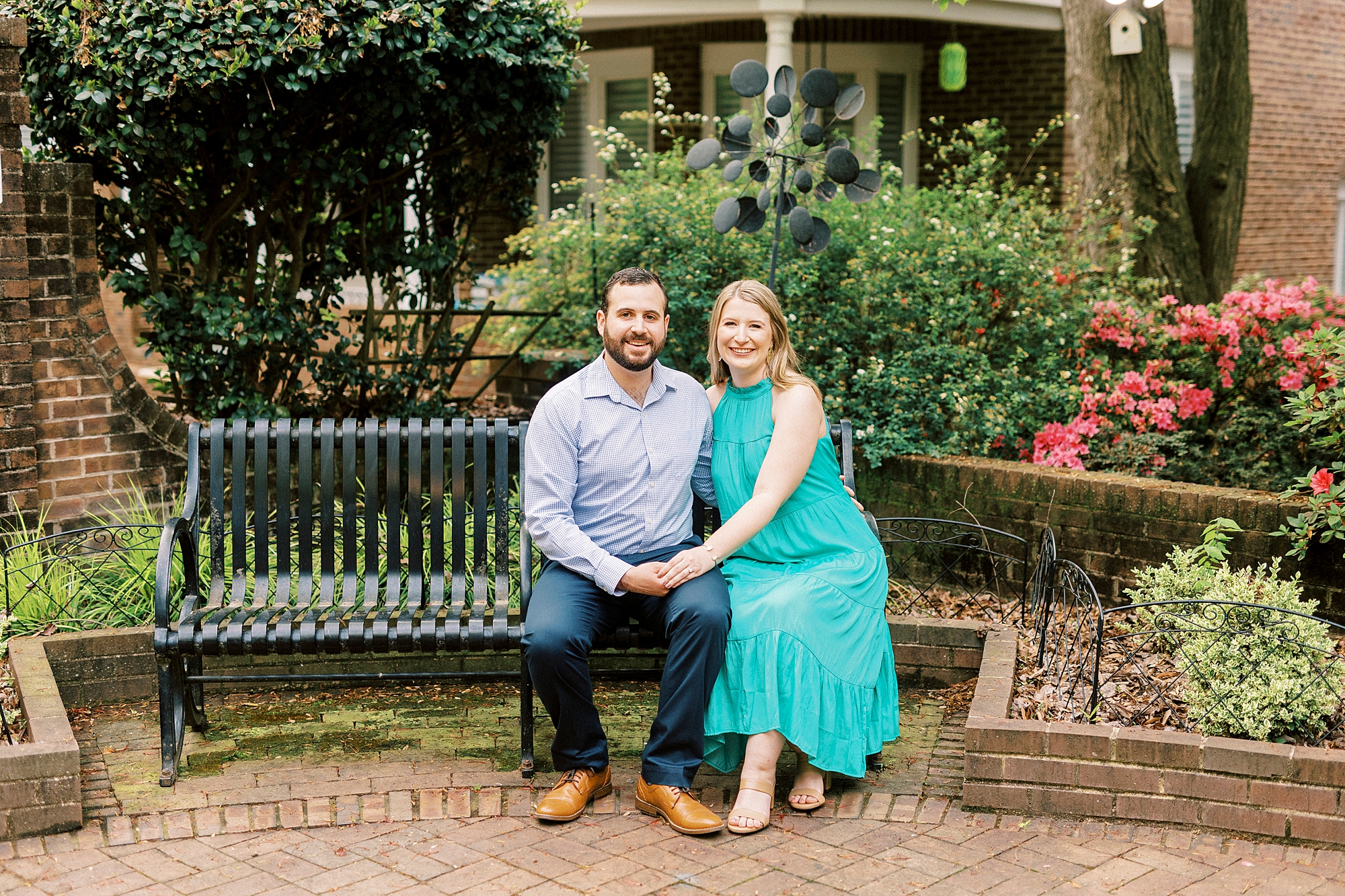 bride and groom sit on green bench outside Fourth Ward Park