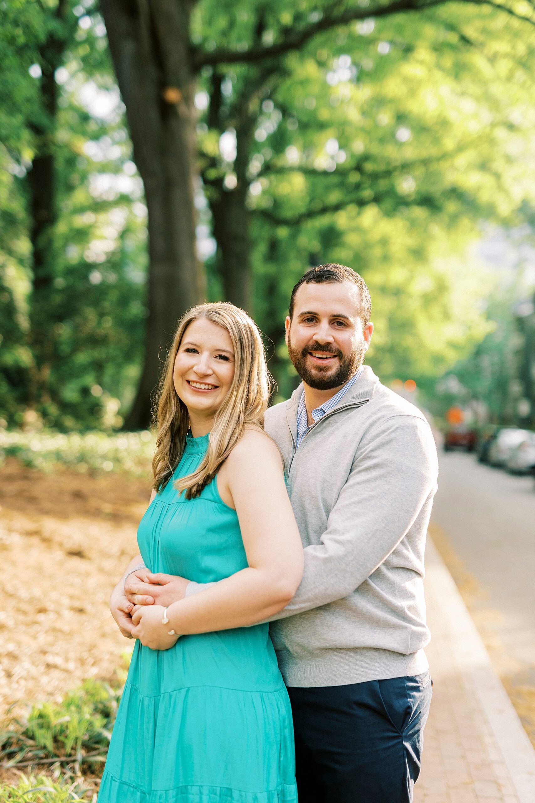 groom hugs bride from behind during spring engagement session 