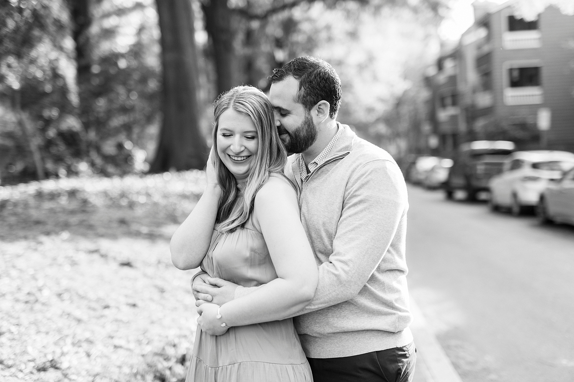 groom hugs bride from behind near Fourth Ward Park