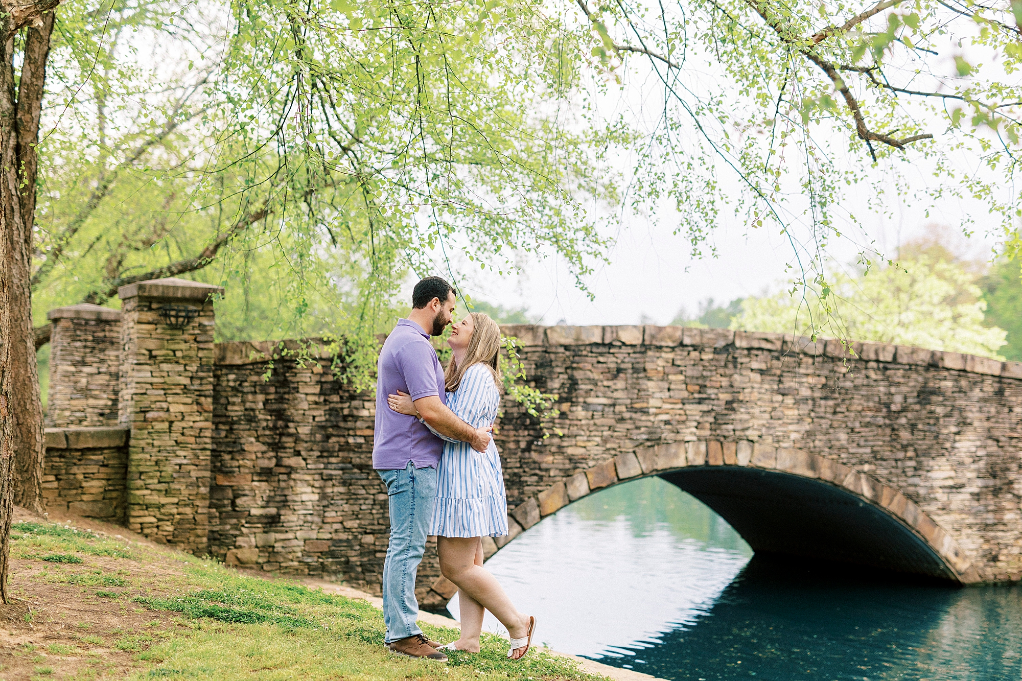 bride and groom kiss near stone bridge in Freedom Park
