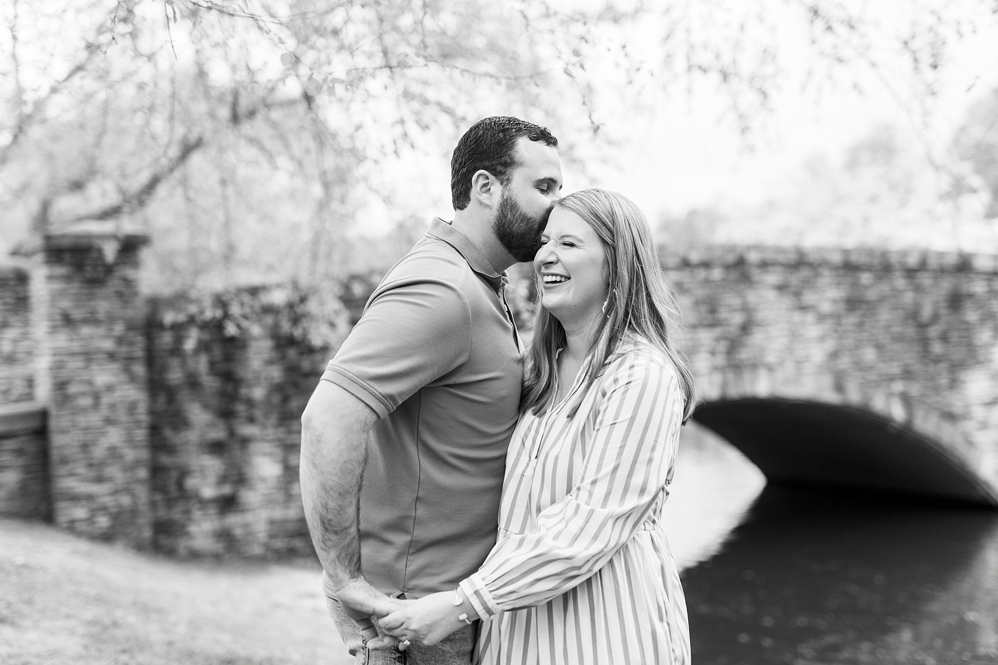 bride and groom laugh together near stone bridge at Freedom Park