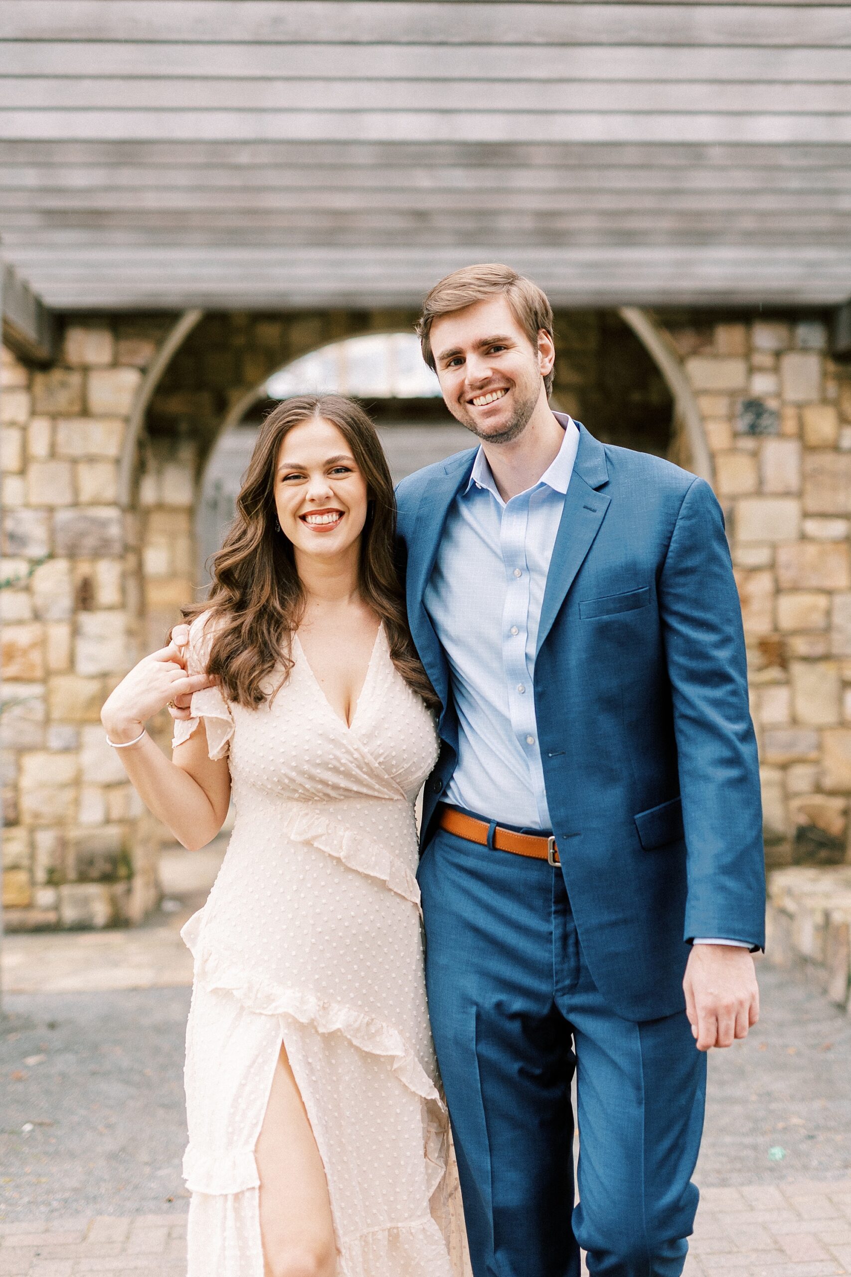 woman in blue dress smiles with fiancee in Midtown Park