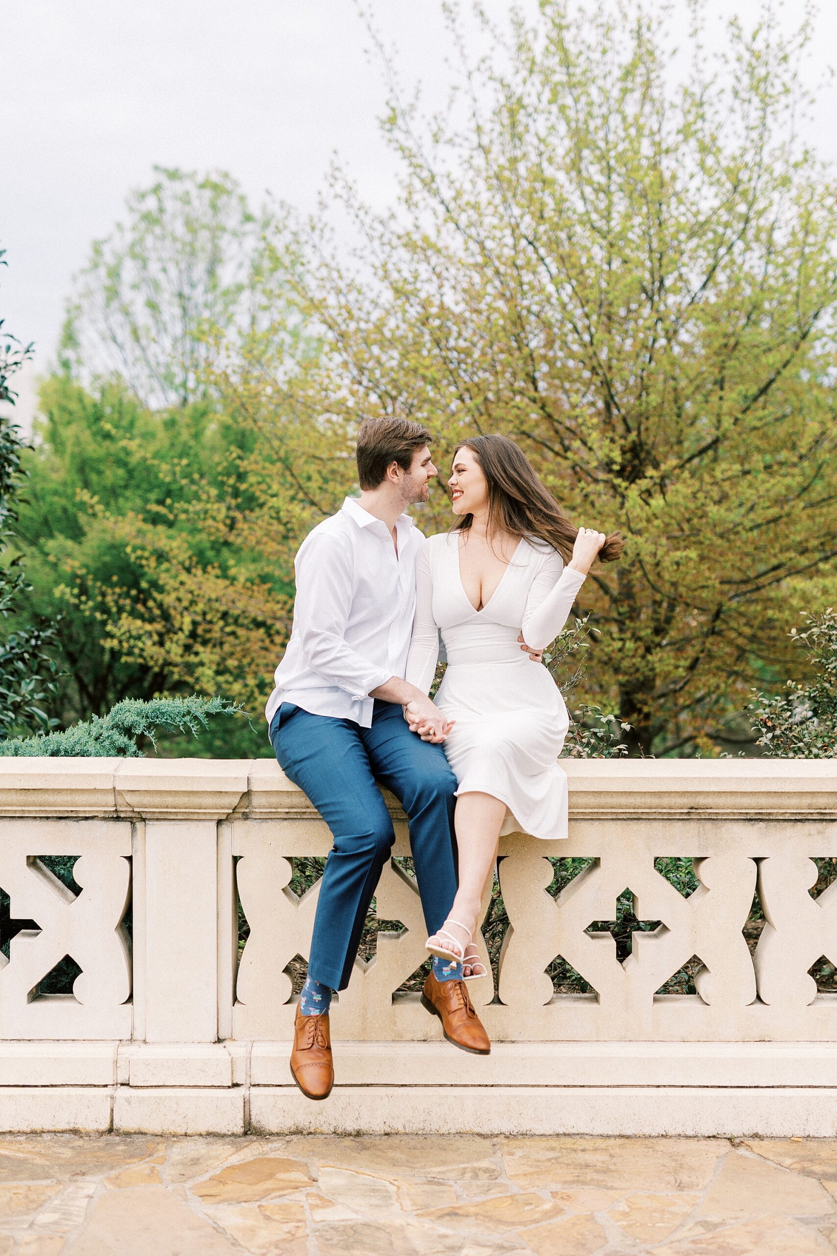 man and woman sit on stone bridge at Midtown Park
