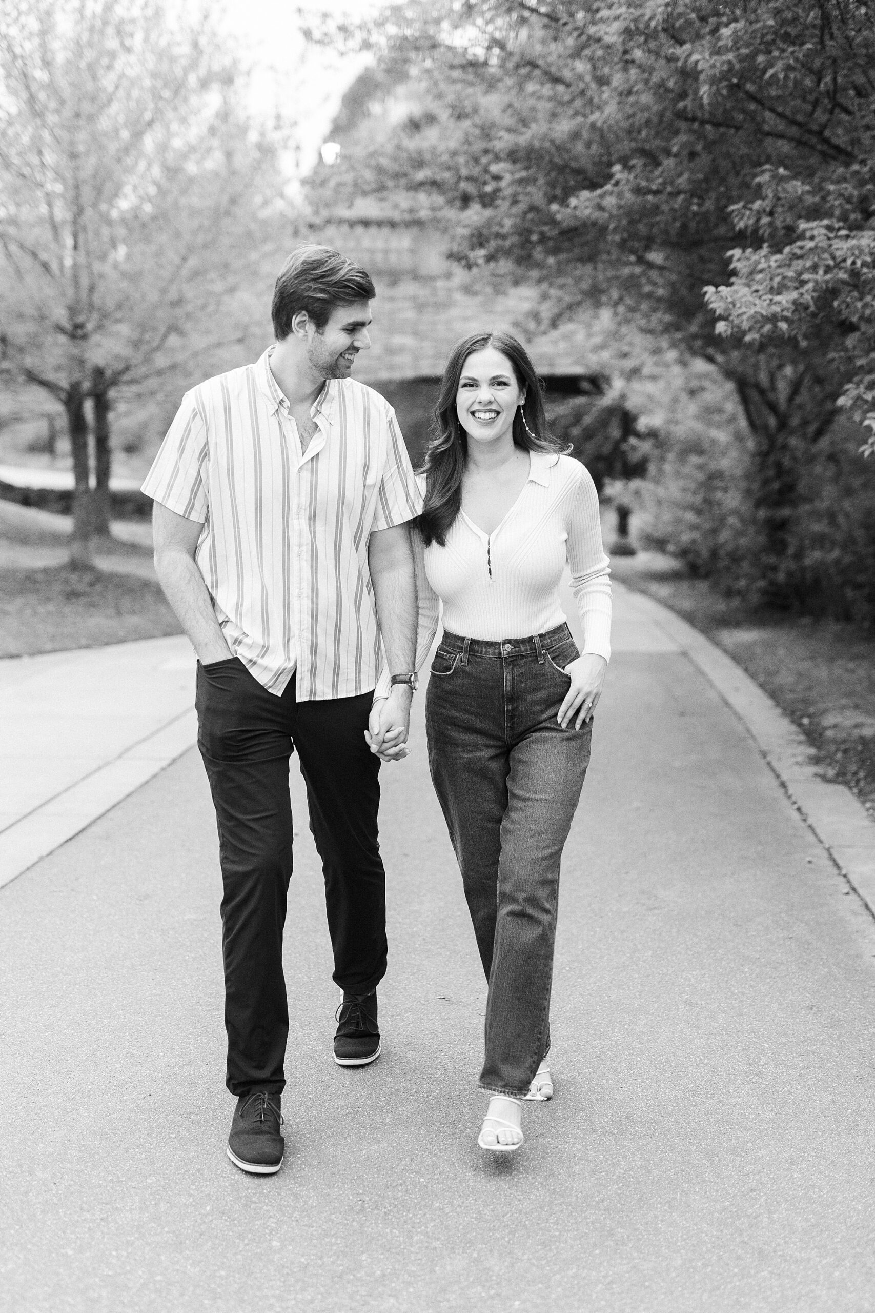couple holds hands walking through Midtown Park