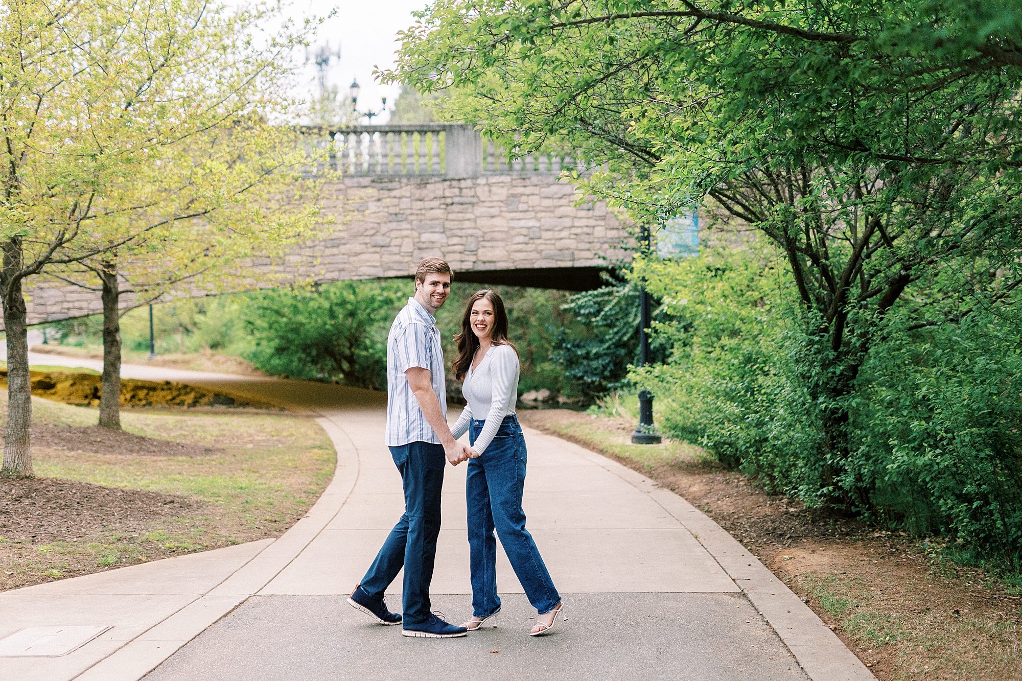 engaged couple smiles turning in Midtown Park