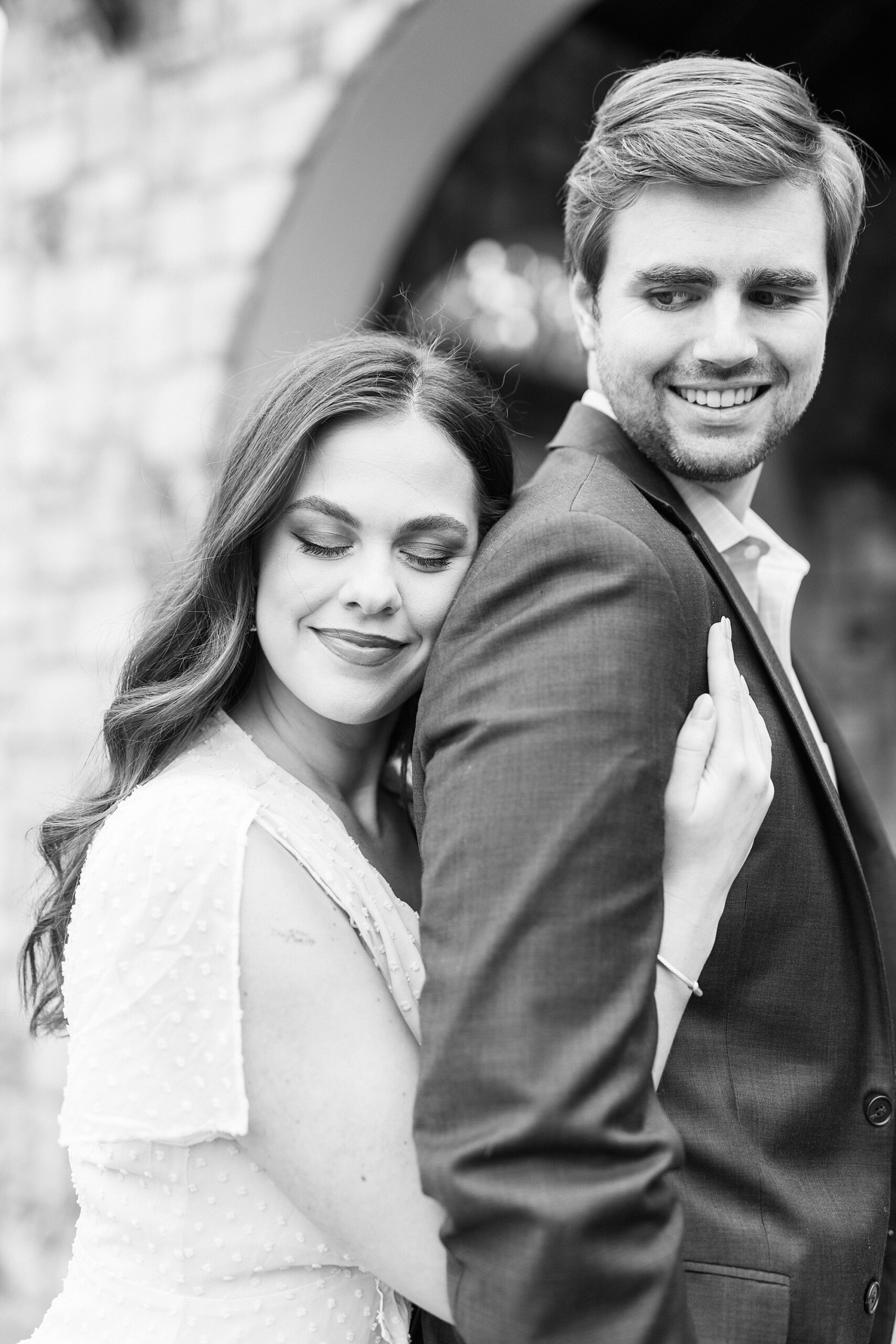 woman hugs man from behind during Midtown Park engagement portraits