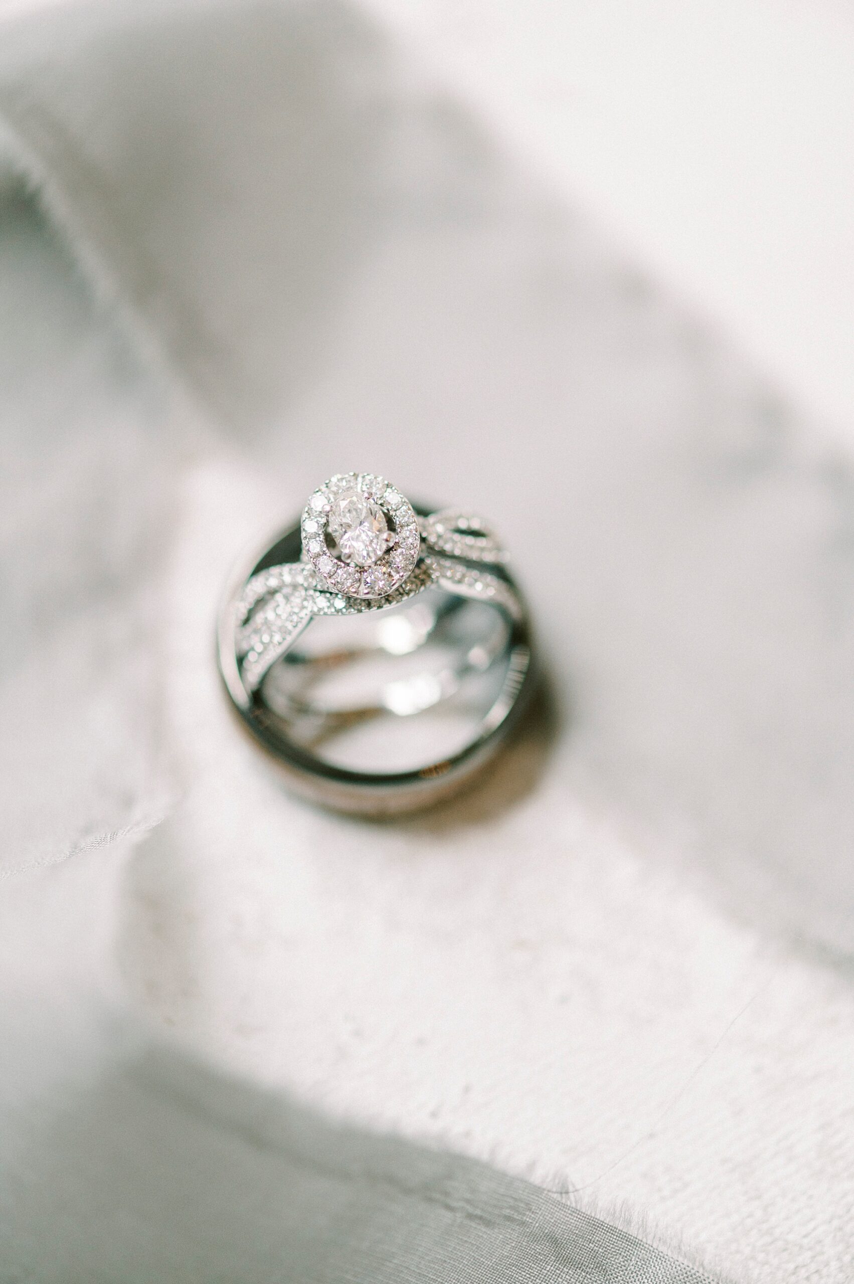 three wedding bands stacked resting on veil 