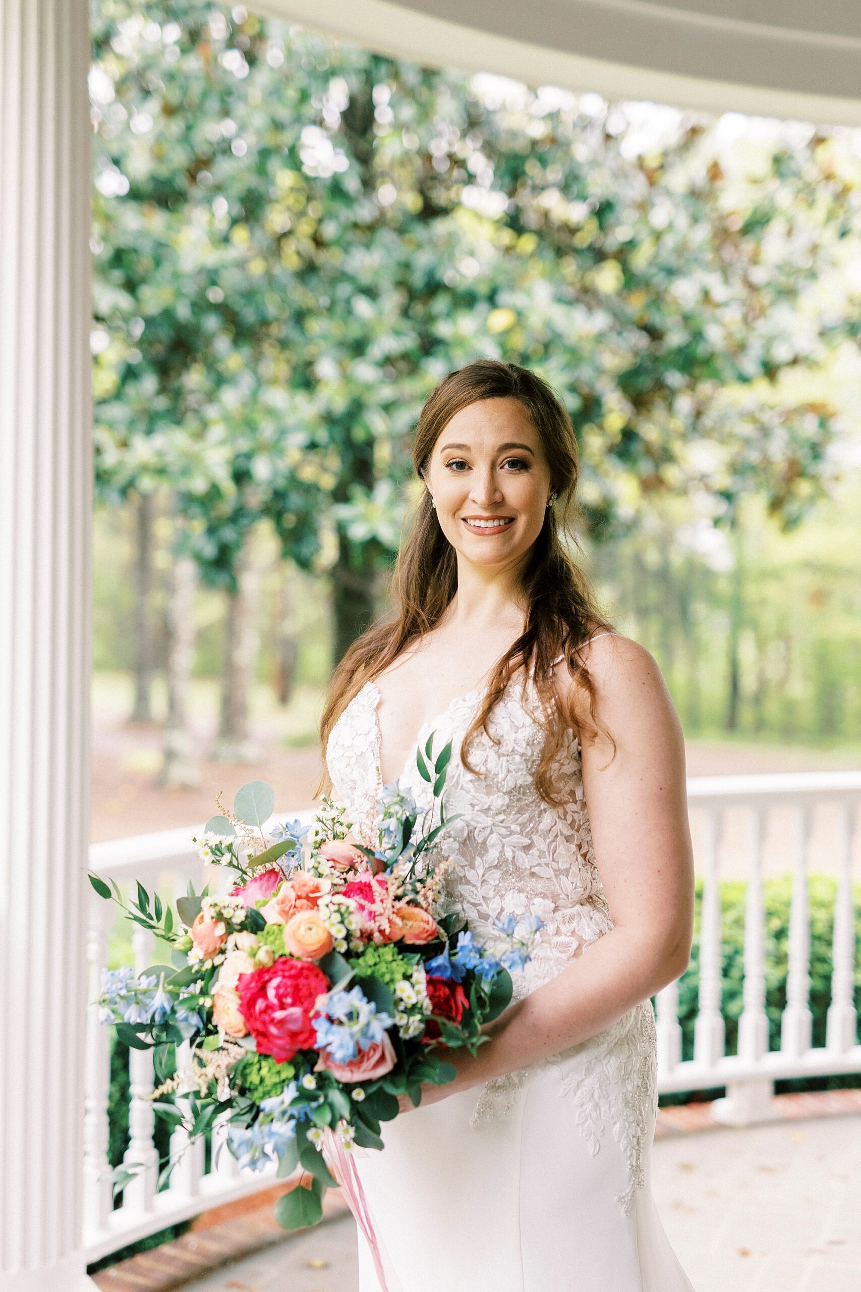 bride holds bouquet of orange flowers on porch at The Saratoga Springs