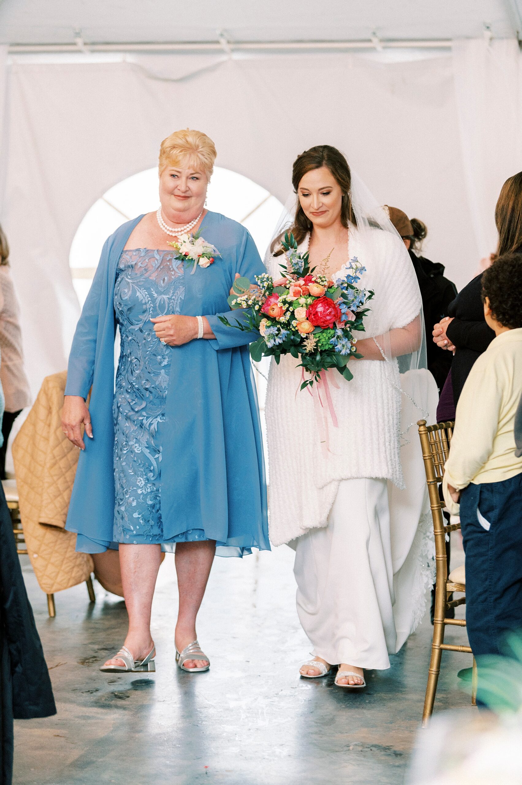 mother in blue dress walks bride down the aisle for wedding ceremony at The Saratoga Springs