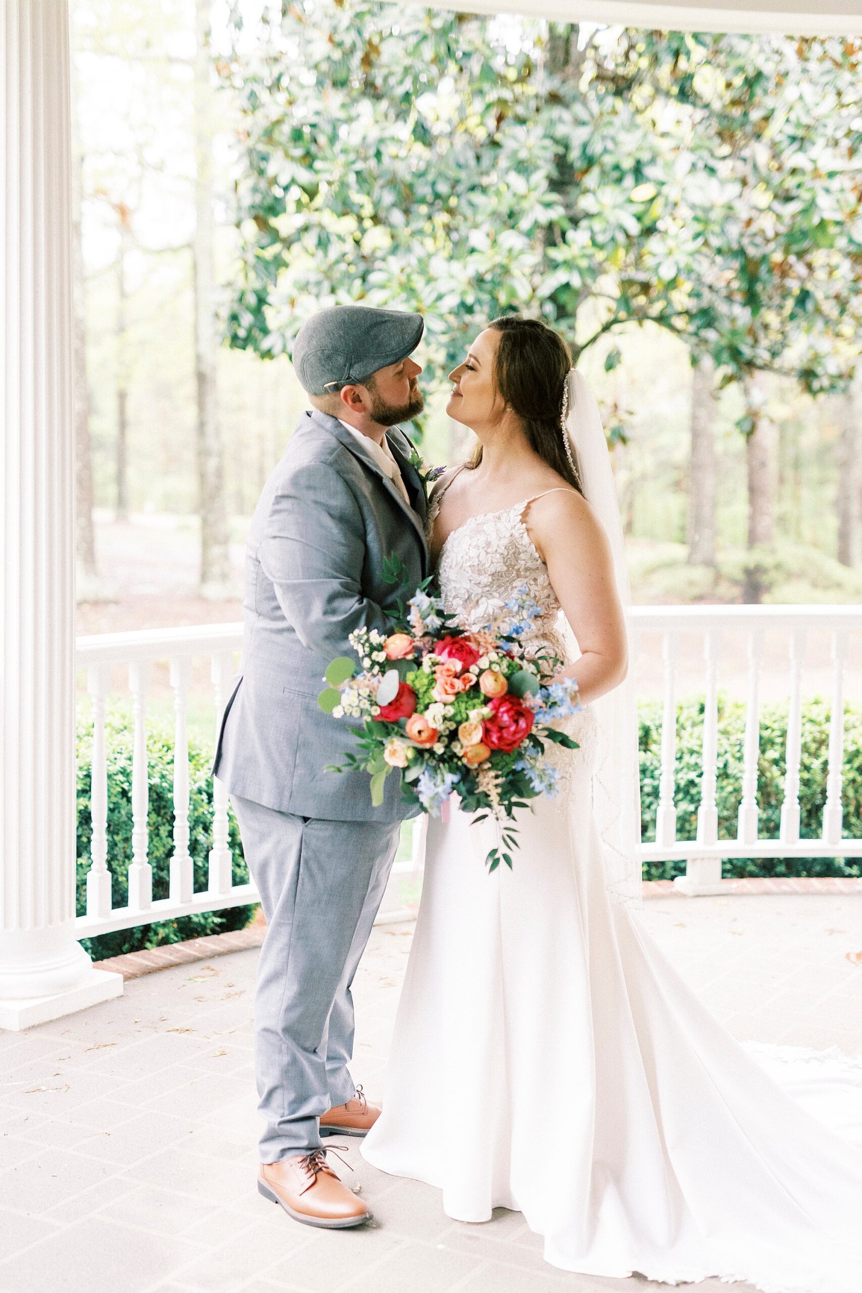 bride and groom kiss on porch at The Saratoga Springs