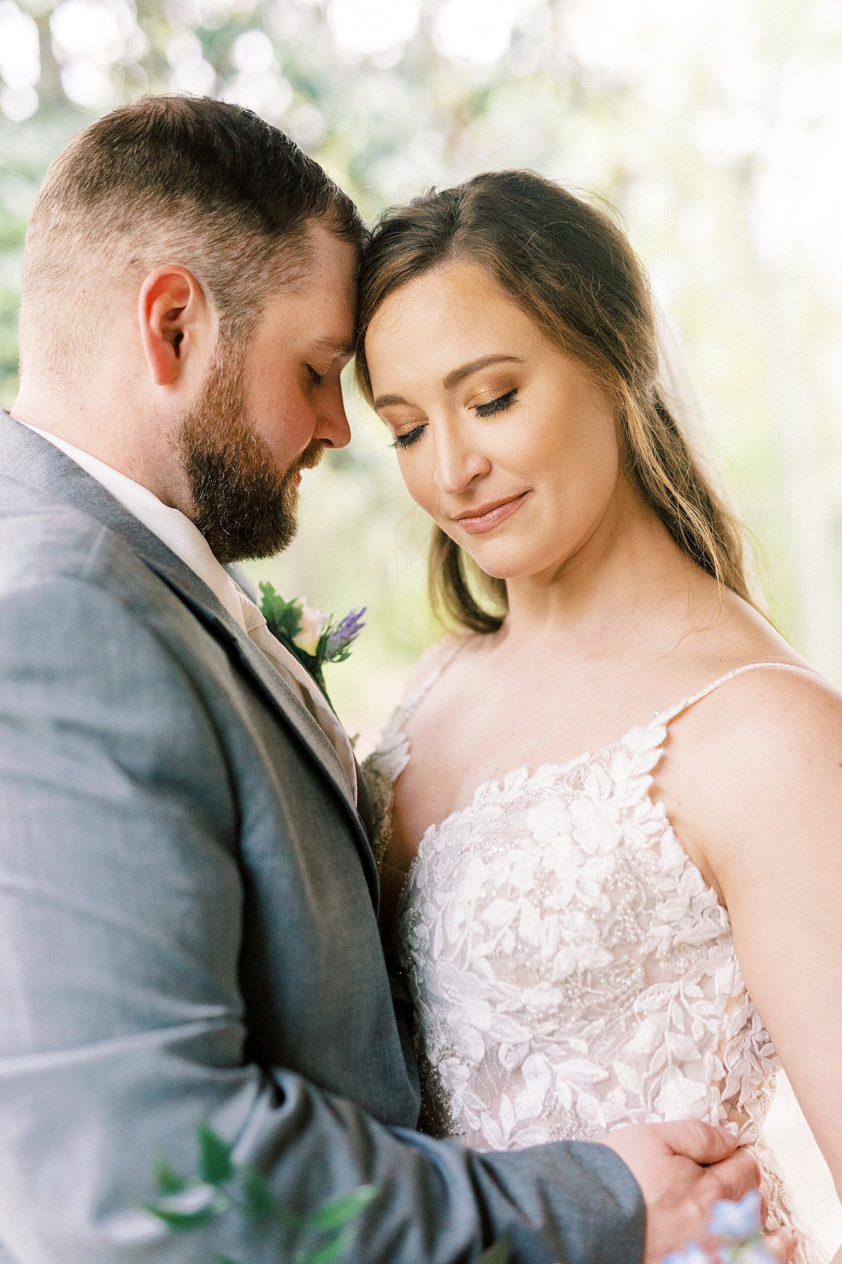 bride and groom lean heads together hugging during Charlotte wedding photos 